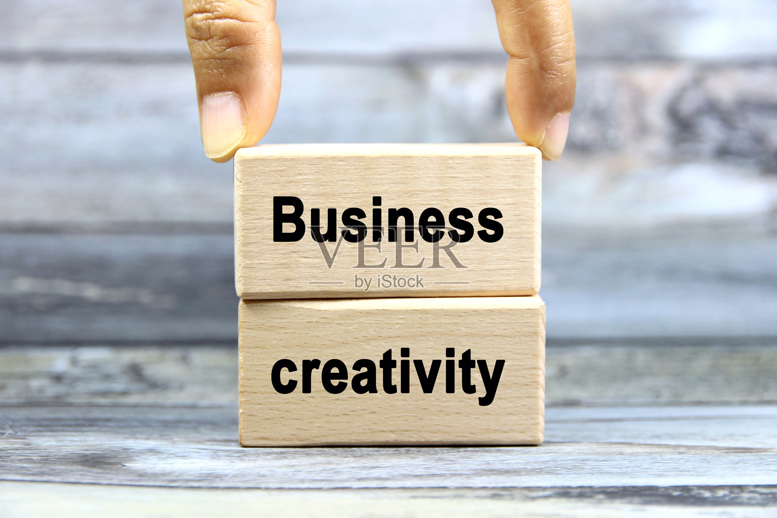 灰色背景上，木块上的商业创意文字或文本，手放在上面。留白和商业概念。照片摄影图片