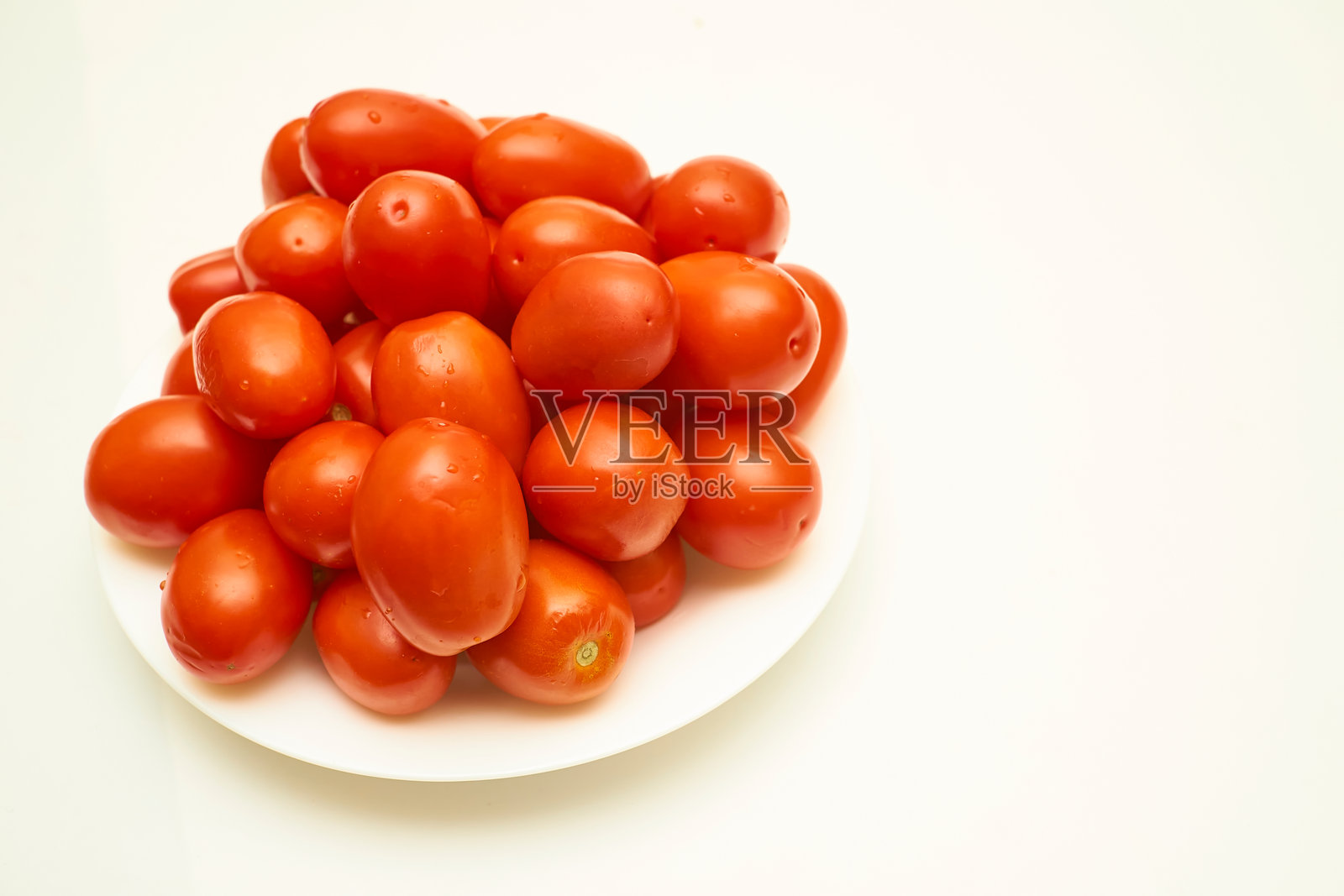 一盘成熟的红色美味番茄，适合烹饪，放在白色背景上。照片摄影图片