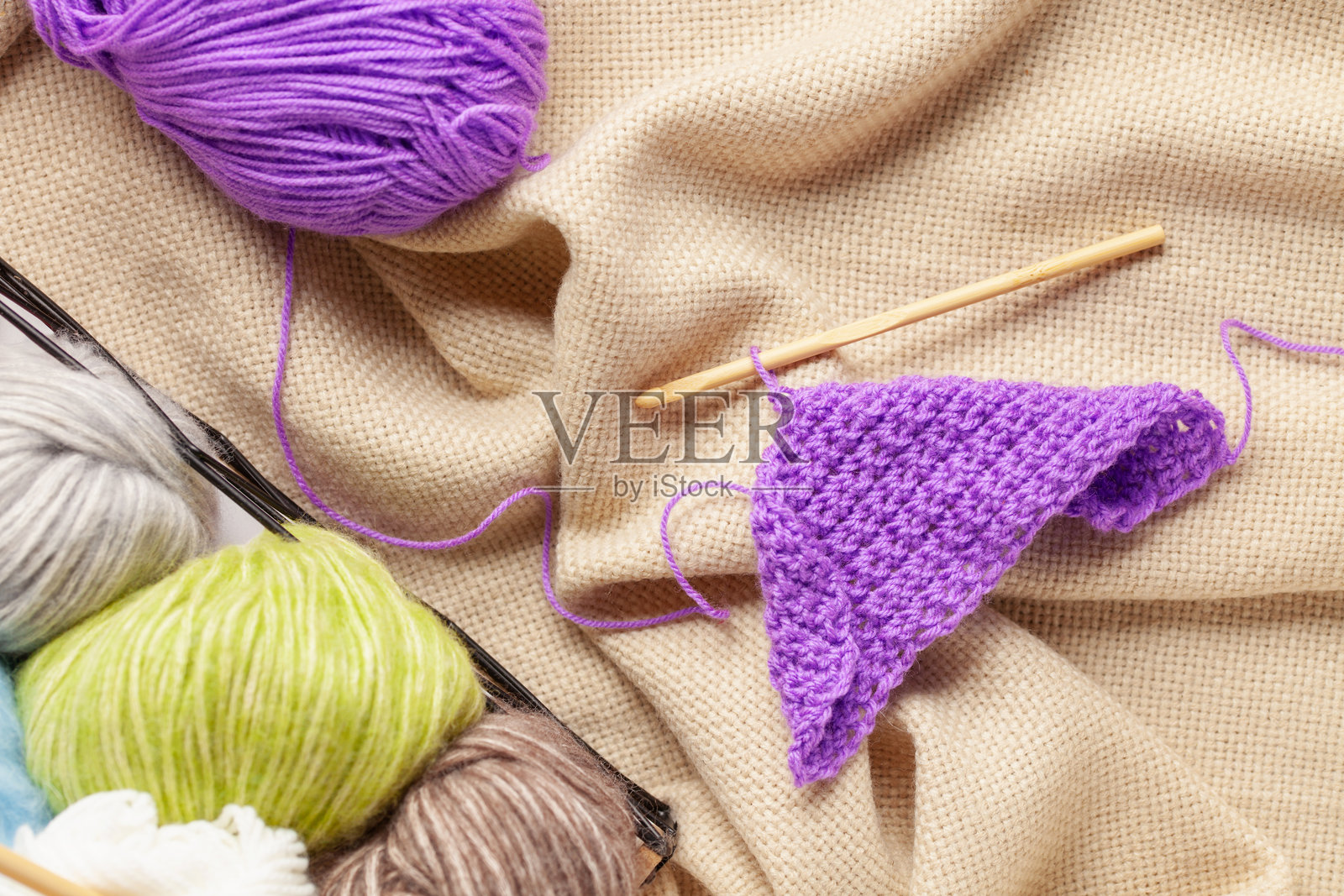 女性编织毛衣。编织针。天然羊毛。俯视图。女性手。照片摄影图片