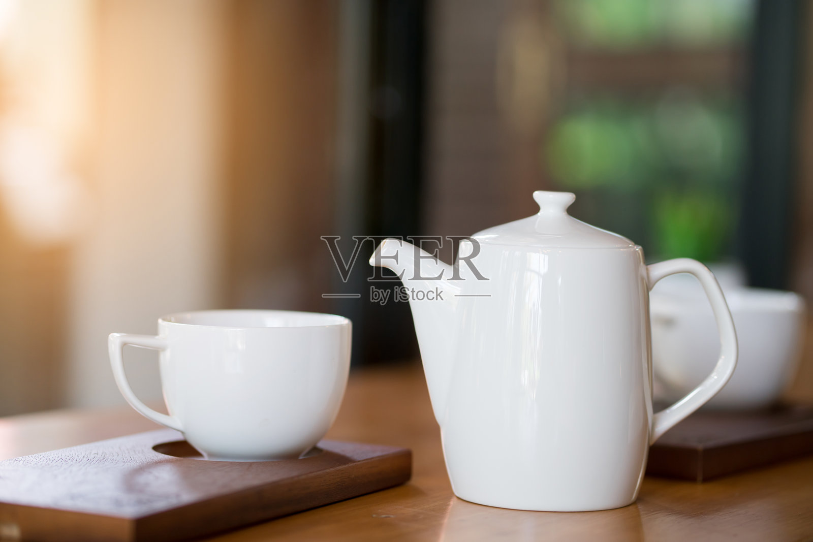 桌子上茶壶旁的咖啡杯特写照片摄影图片