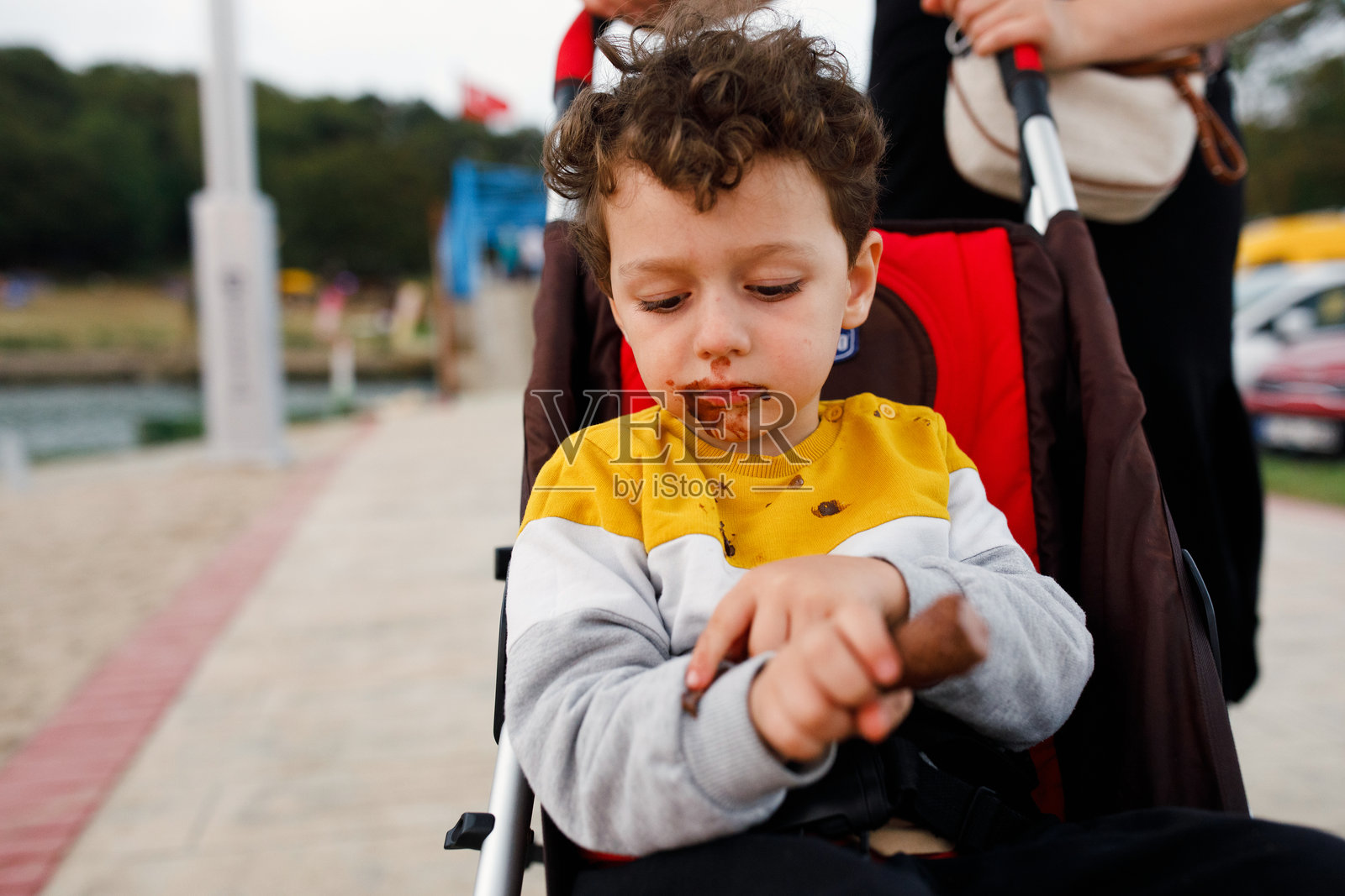美味的休息：男孩在婴儿车里放松，享受冰淇淋照片摄影图片