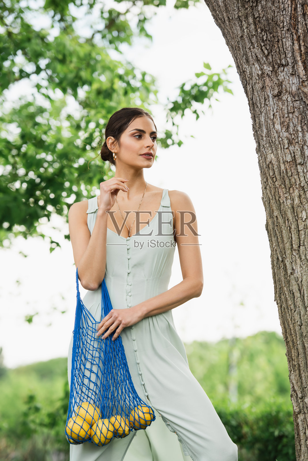 一位年轻女性通过使用可重复使用的购物袋来践行可持续生活，购买新鲜农产品。照片摄影图片