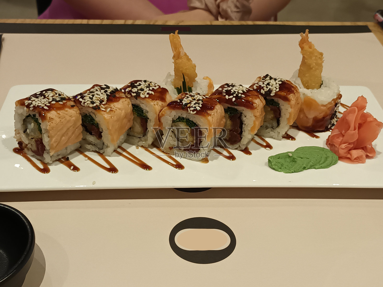 精致的三文鱼寿司卷，配以装饰，盛放在白色盘子上。天妇罗虾。高档餐饮。照片摄影图片