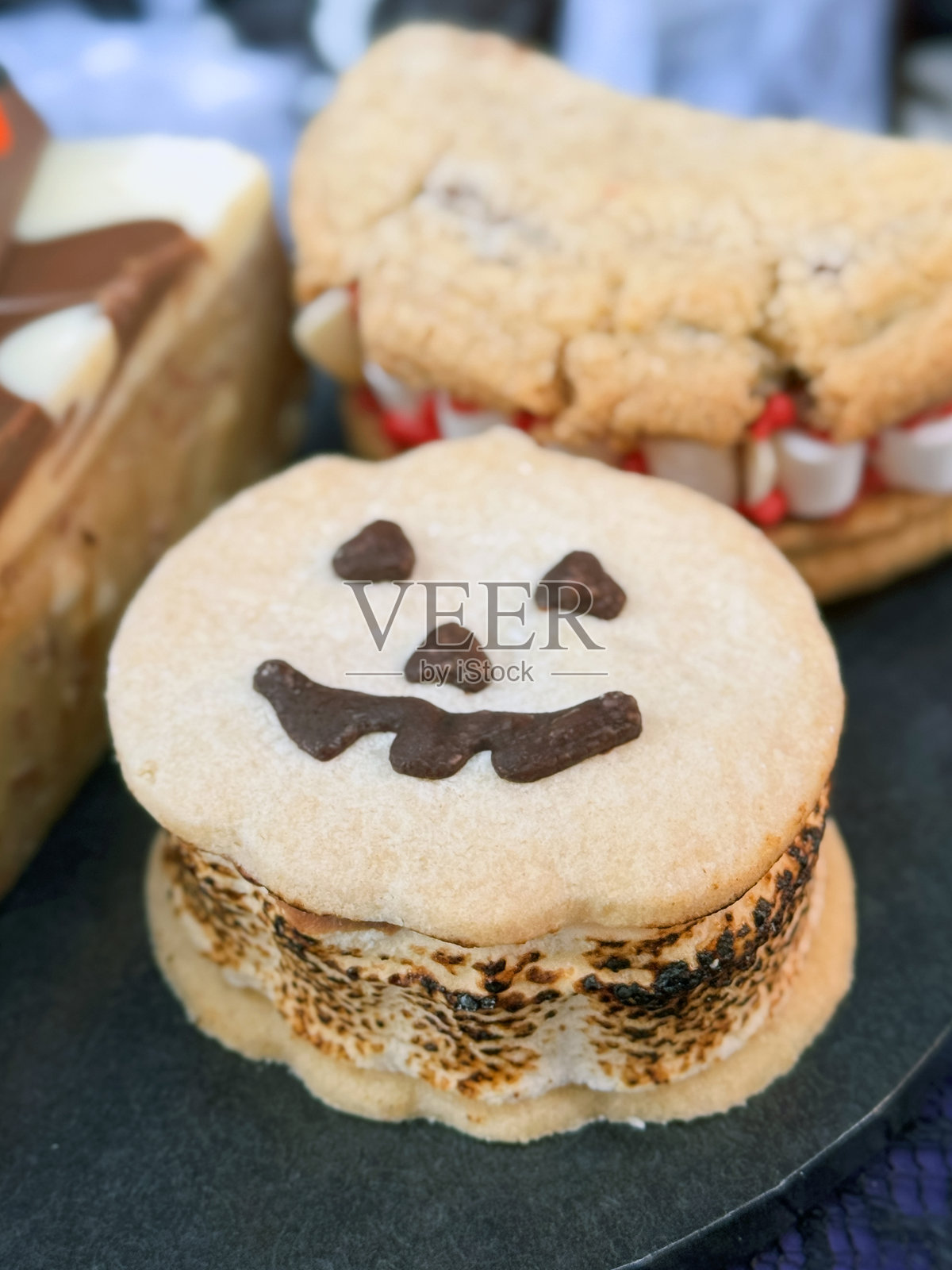 节日万圣节美食的图片 / 南瓜杰克南瓜灯蛋糕、带巧克力嘴巴的幽灵饼干和美味的饼干照片摄影图片