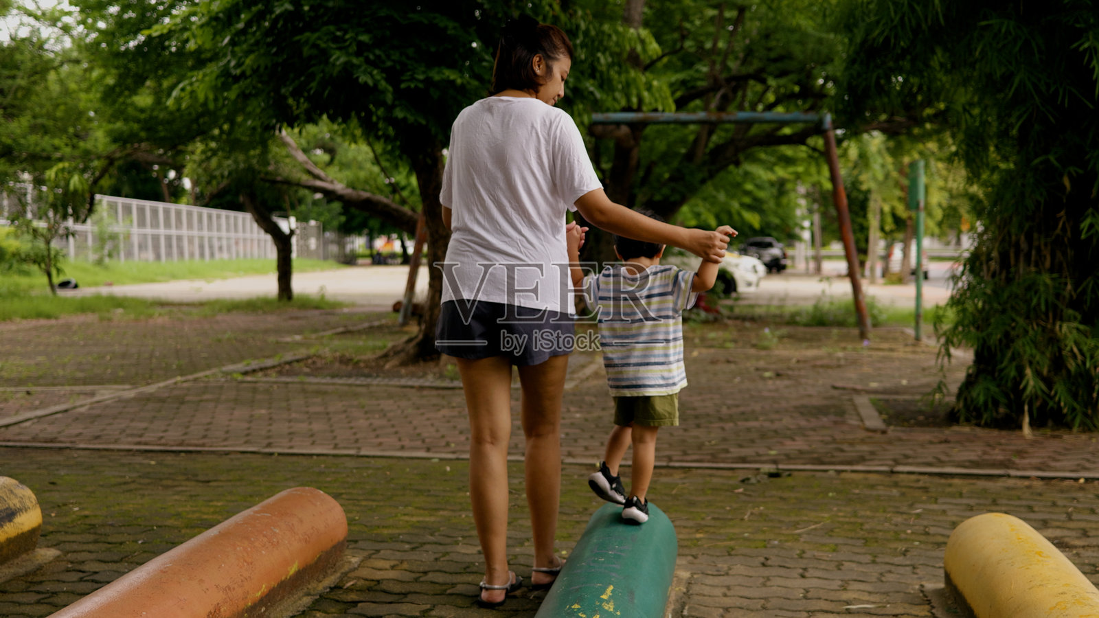 亚洲母亲带着儿子走上陡峭的小路练习平衡和冒险。照片摄影图片