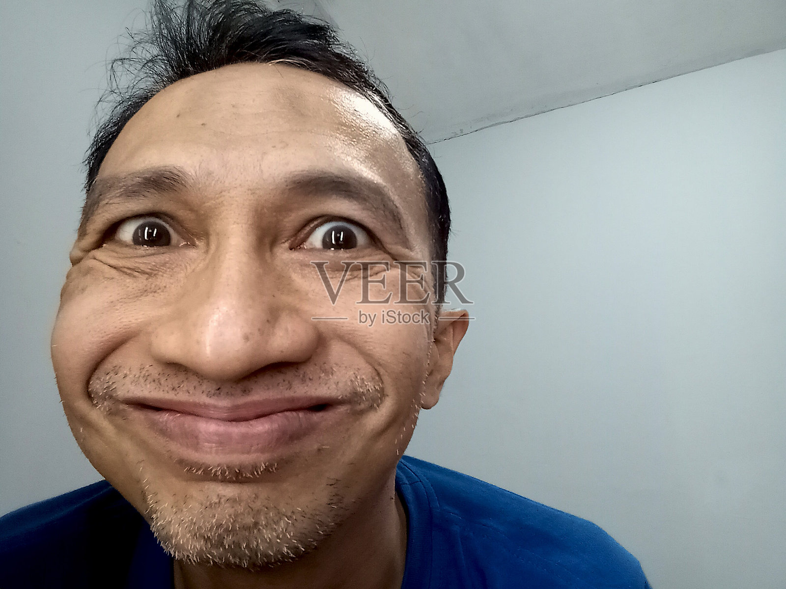 一个面部表情奇怪而滑稽的男人。照片摄影图片