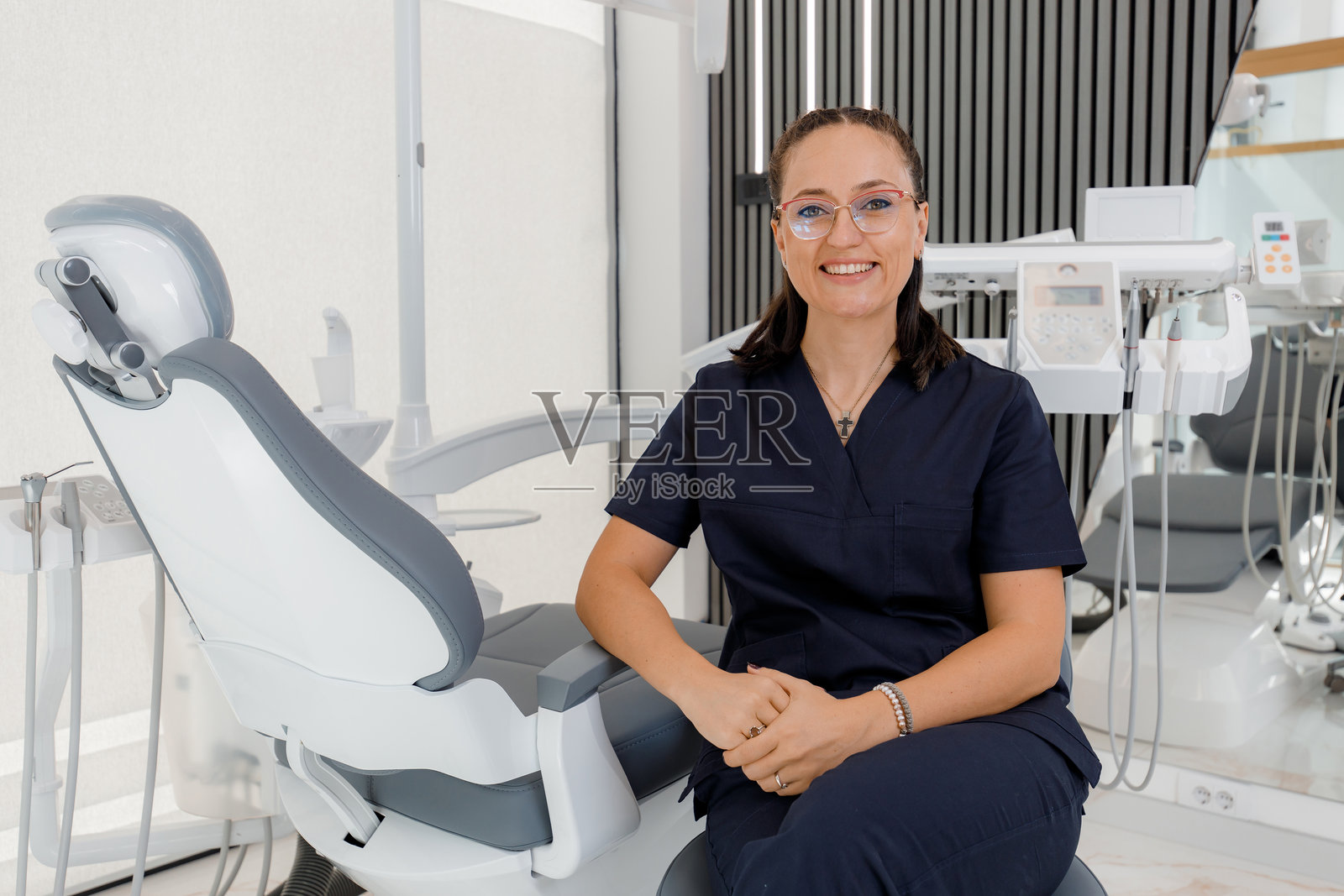 牙科专业人士在现代诊所环境中微笑，与患者进行咨询照片摄影图片