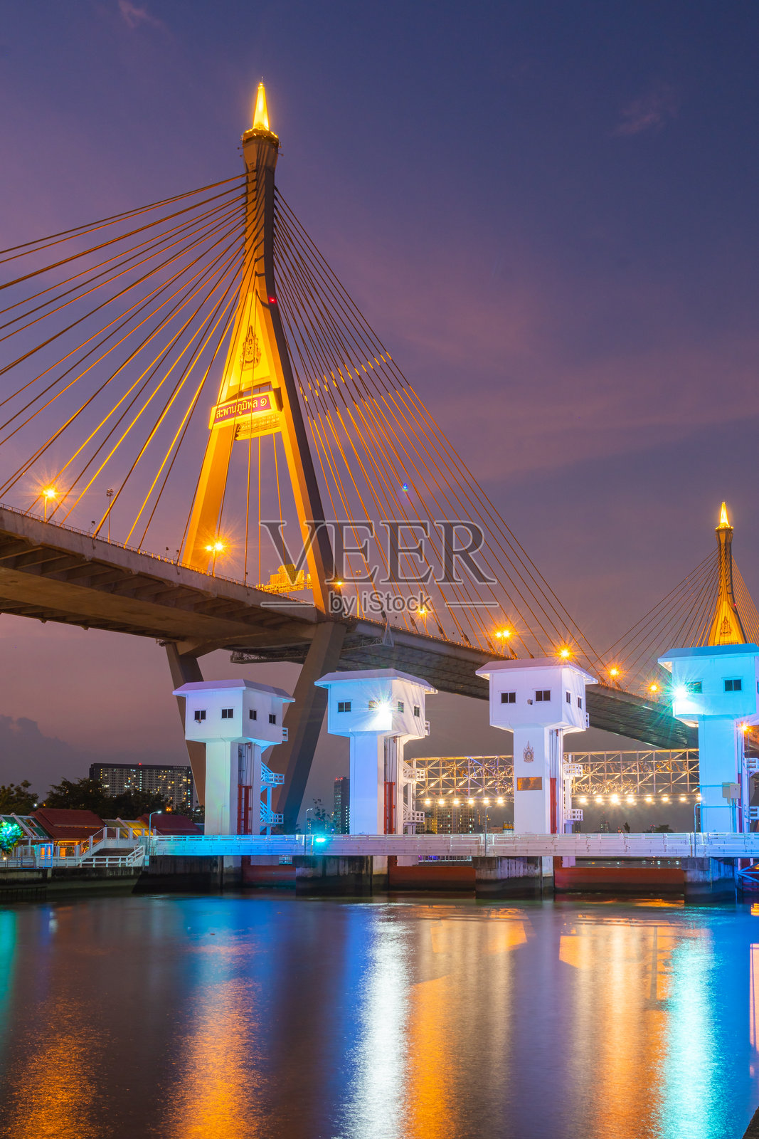 布美邦桥黄昏时分的壮丽景色，展示了其令人印象深刻的建筑和在水面上反射的绚丽灯光。场景捕捉了城市工程的美丽与宁静。照片摄影图片