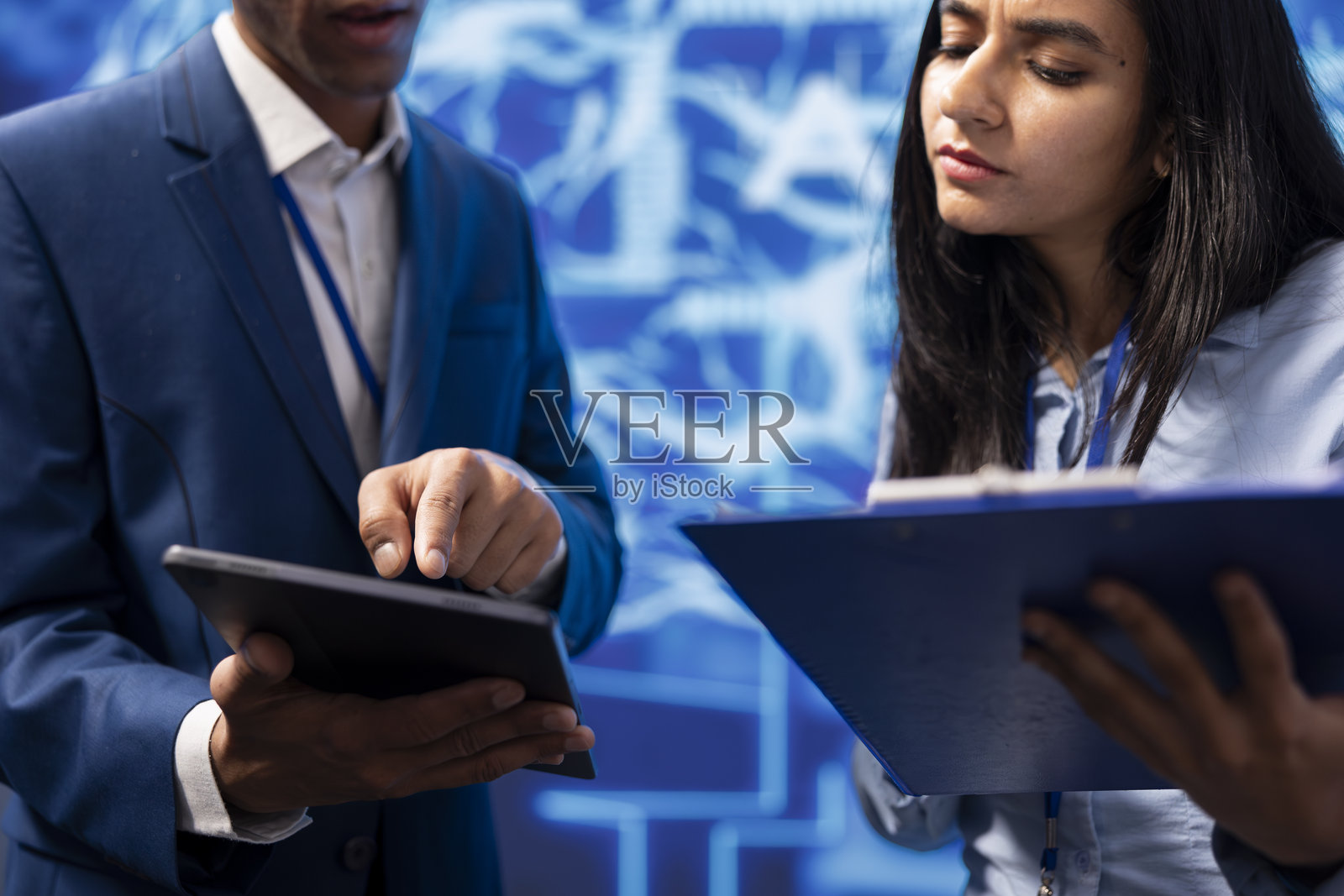 开发者和同事在平板电脑上分析复杂的人工智能大脑模型照片摄影图片