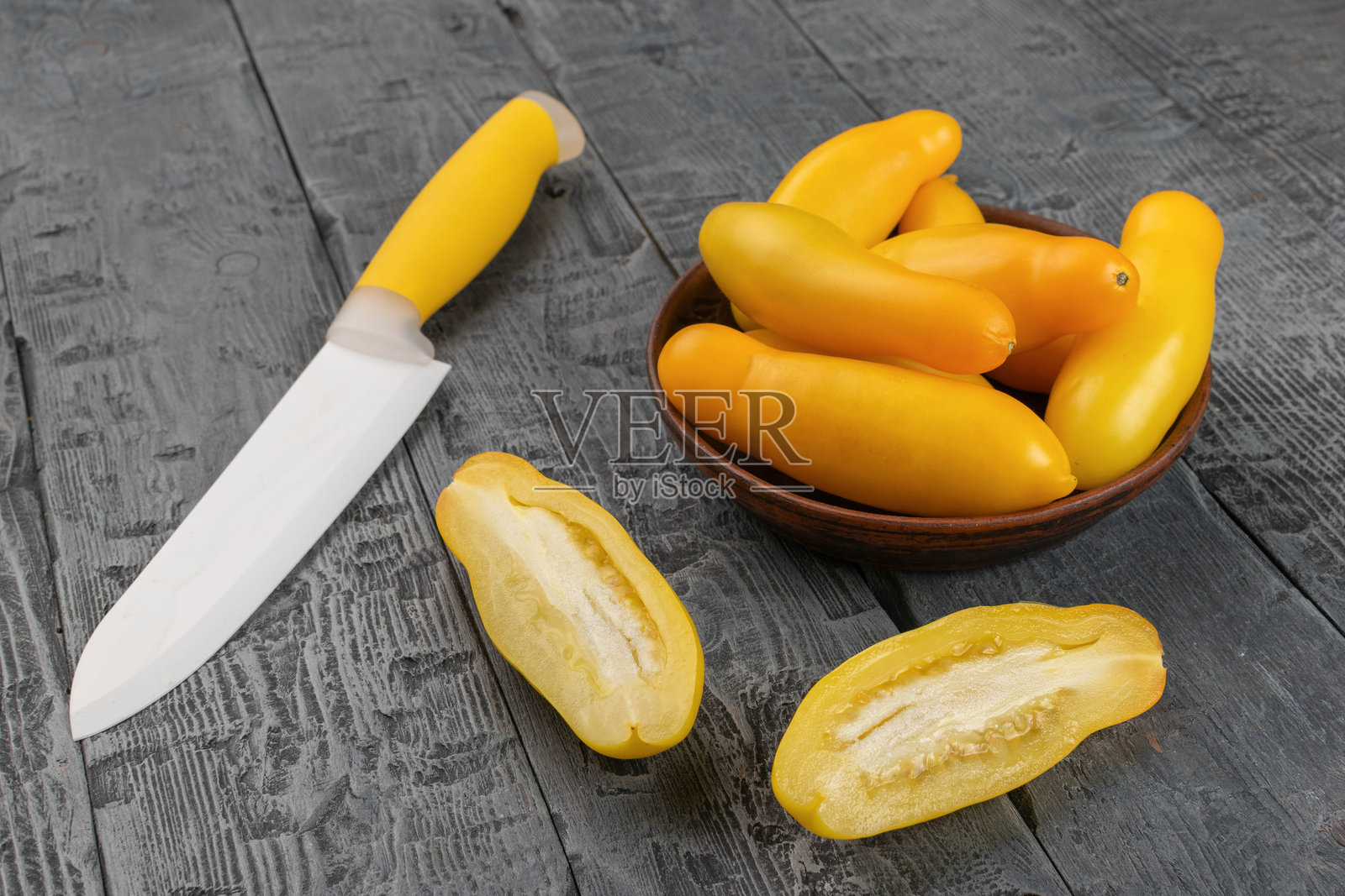 新鲜的黄色番茄与刀具放在乡村风格的木桌上照片摄影图片