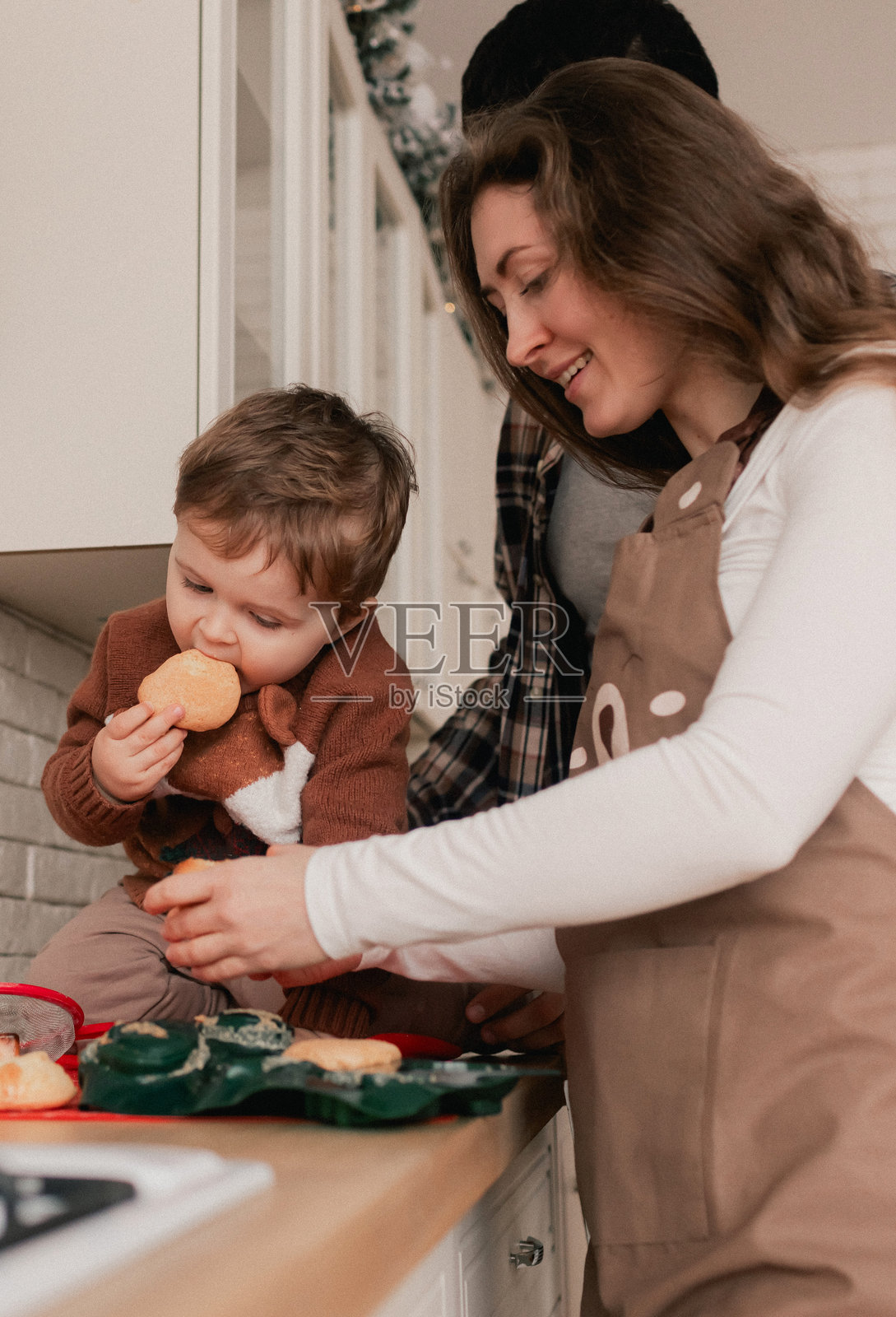 家庭快乐时光，与亲人在圣诞前夕共度的时光。新年、母亲节和父亲节的礼物概念。现代厨房室内。系列的一部分。照片摄影图片