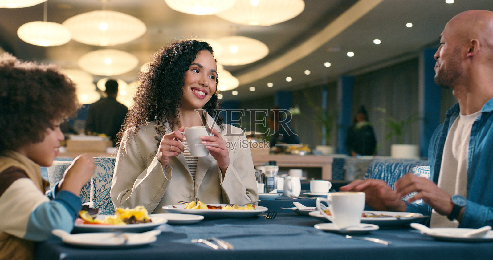 人们在餐厅聚会，共享午餐或晚餐，作为父母享受乐趣、放松和美食。女人、孩子和男人一起用餐，幸福地庆祝家庭的爱或生日。照片摄影图片