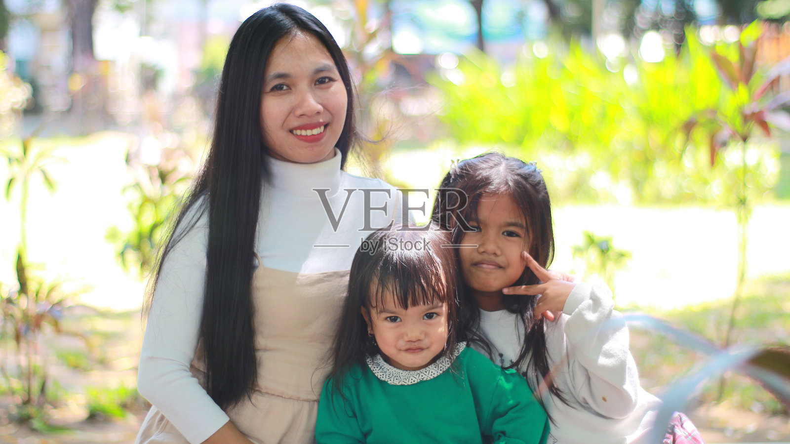 快乐的家庭时光：母亲和女儿们在公园里欢笑在一起照片摄影图片