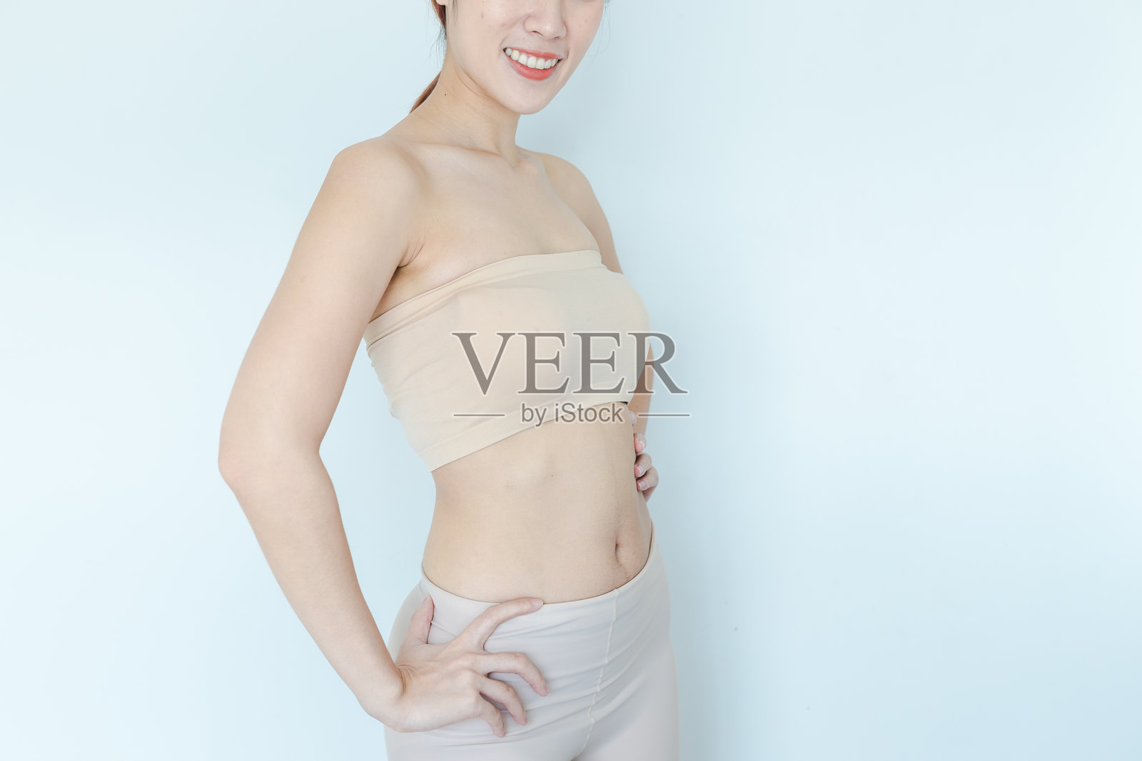 瘦女性的中部站立在白色背景前照片摄影图片