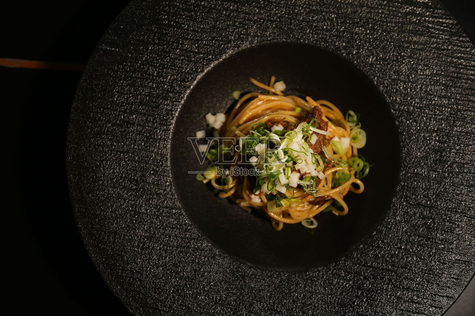 黑色盘子上的美食意大利面菜肴照片摄影图片