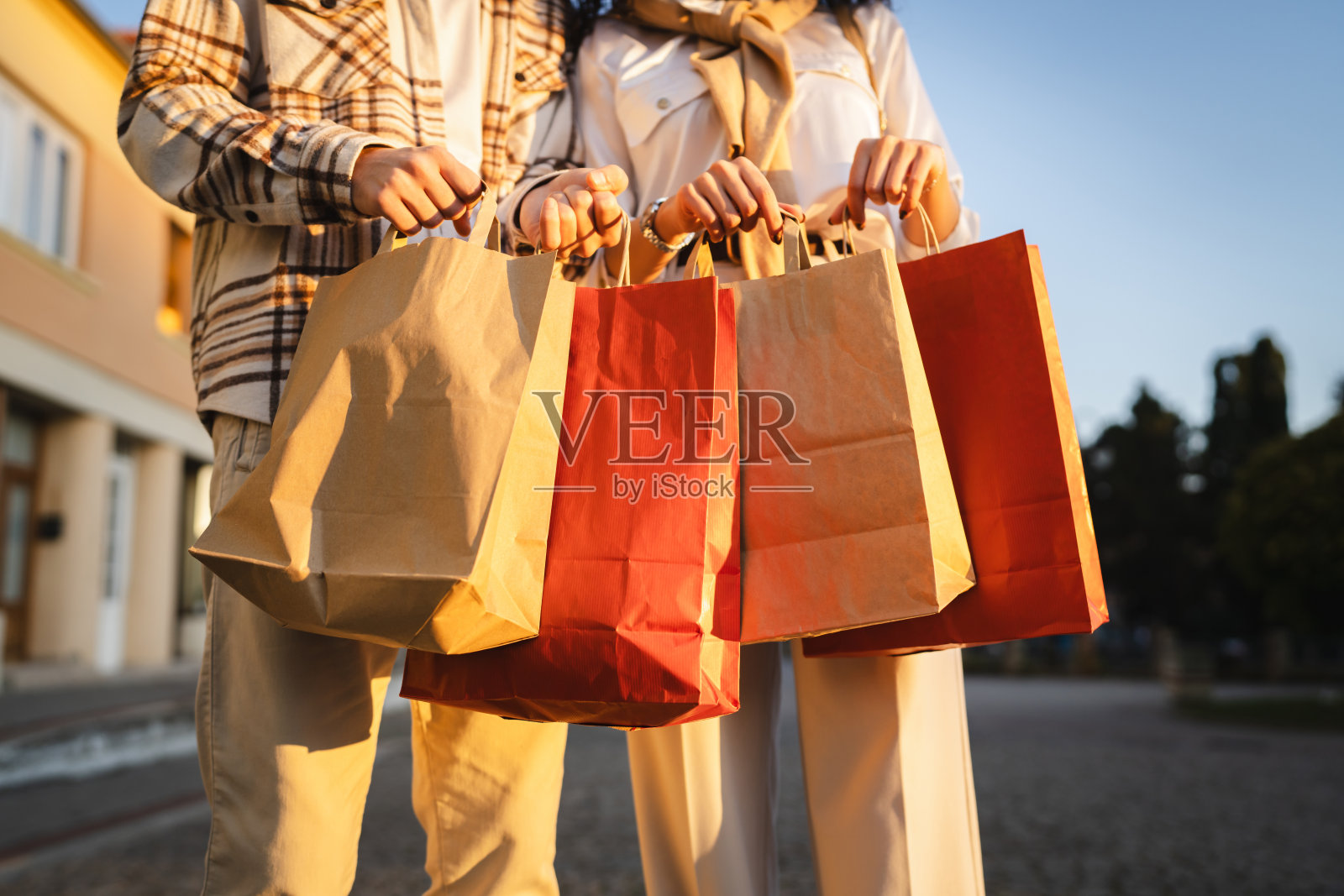 男人和女人的手在户外紧握着五颜六色的购物袋特写镜头照片摄影图片