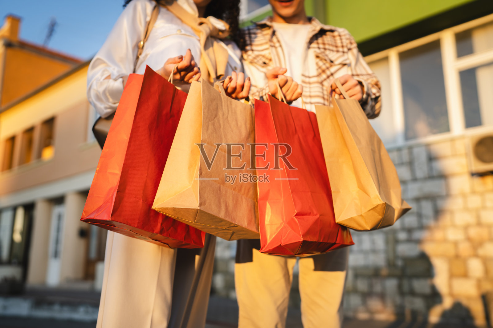 男人和女人的手在户外紧握着五颜六色的购物袋特写镜头照片摄影图片