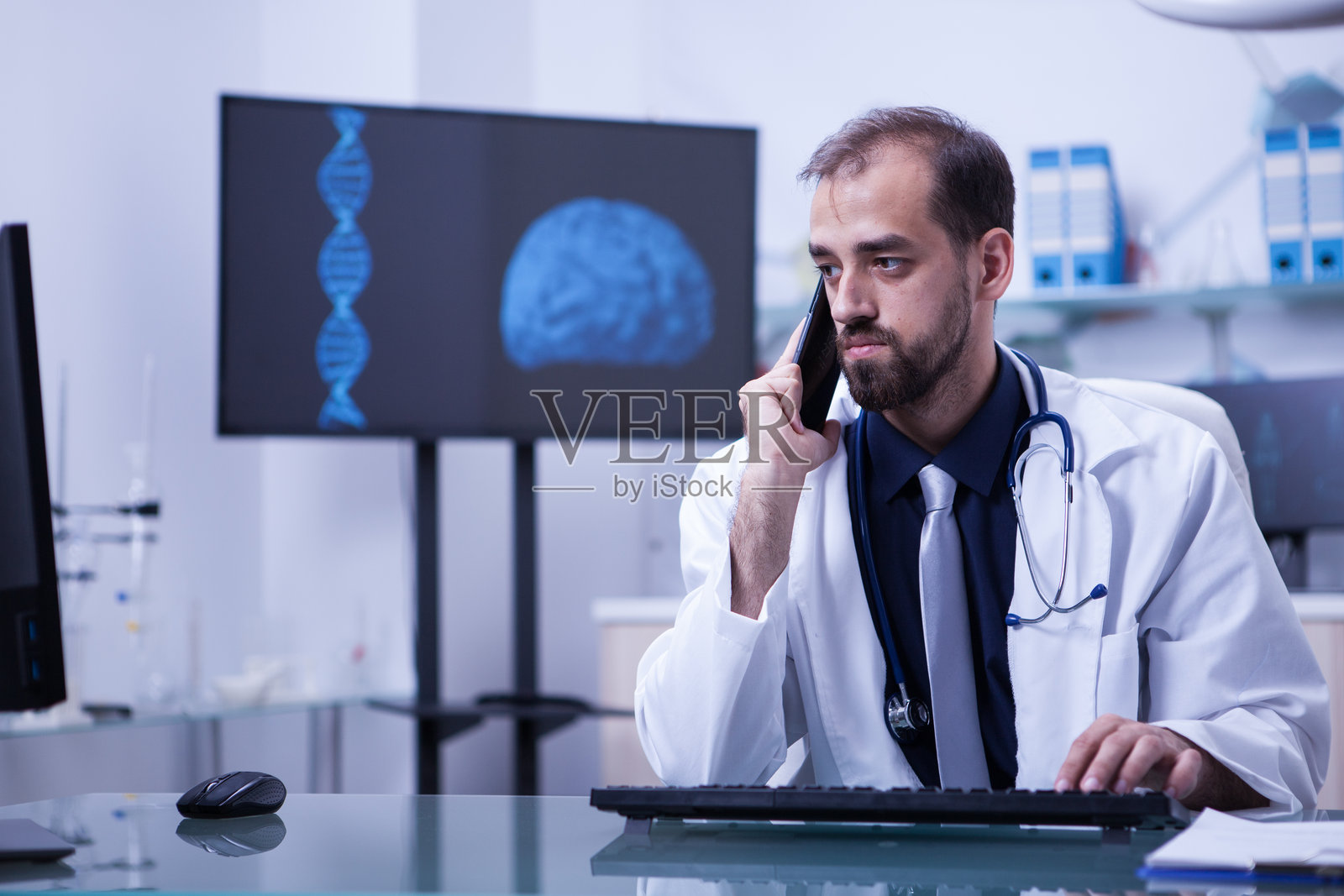 穿着白大褂的医生在医院办公室接电话照片摄影图片