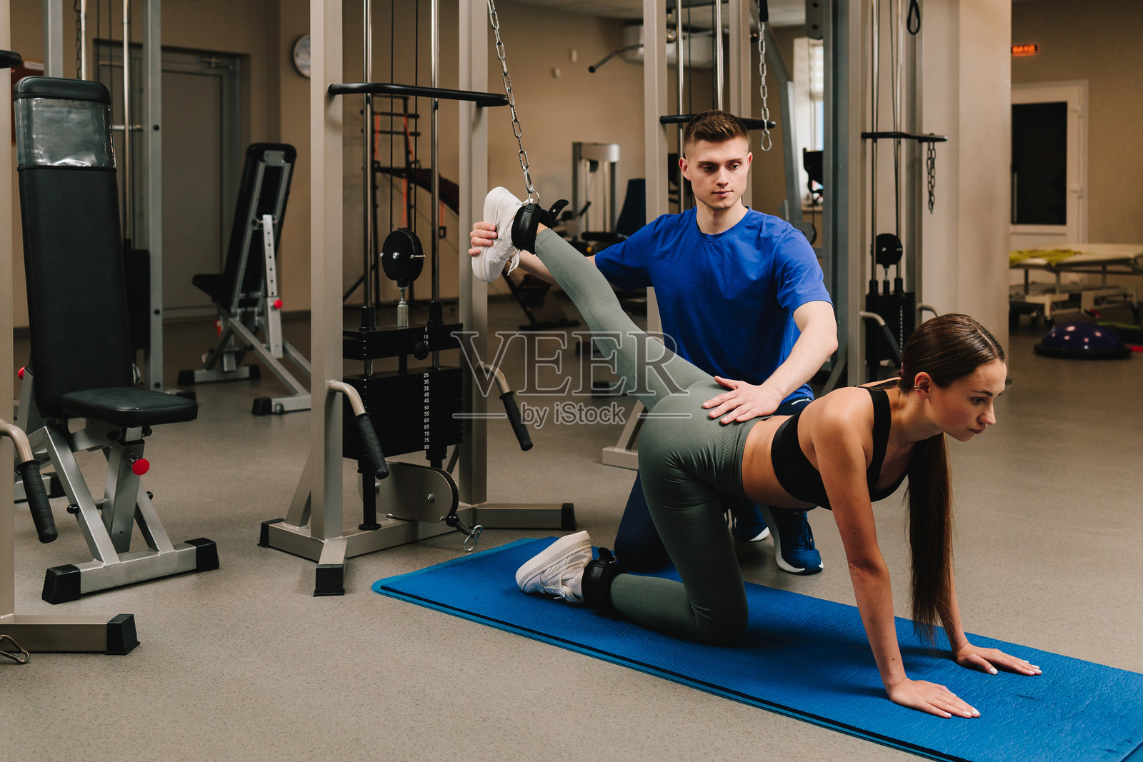通过运动疗法预防类风湿性疾病。运动治疗师正在协助他的女性患者进行背部康复锻炼。照片摄影图片