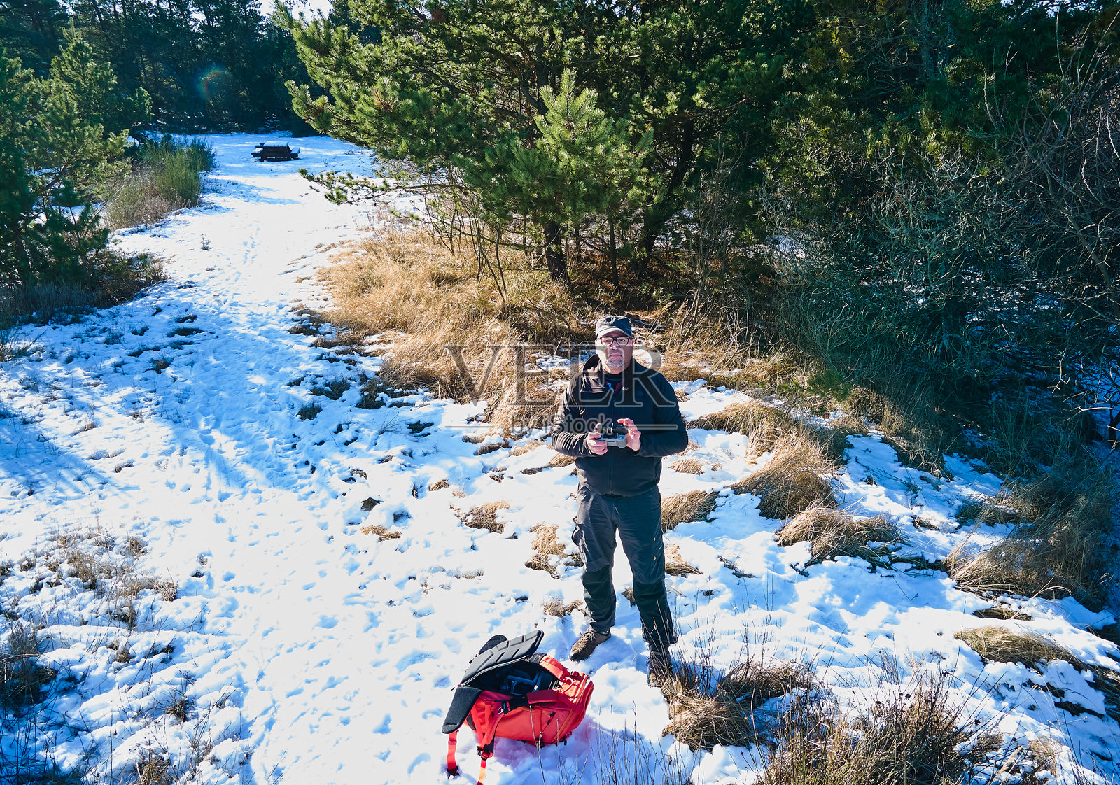 男子在冬季森林中使用无人机遥控器照片摄影图片