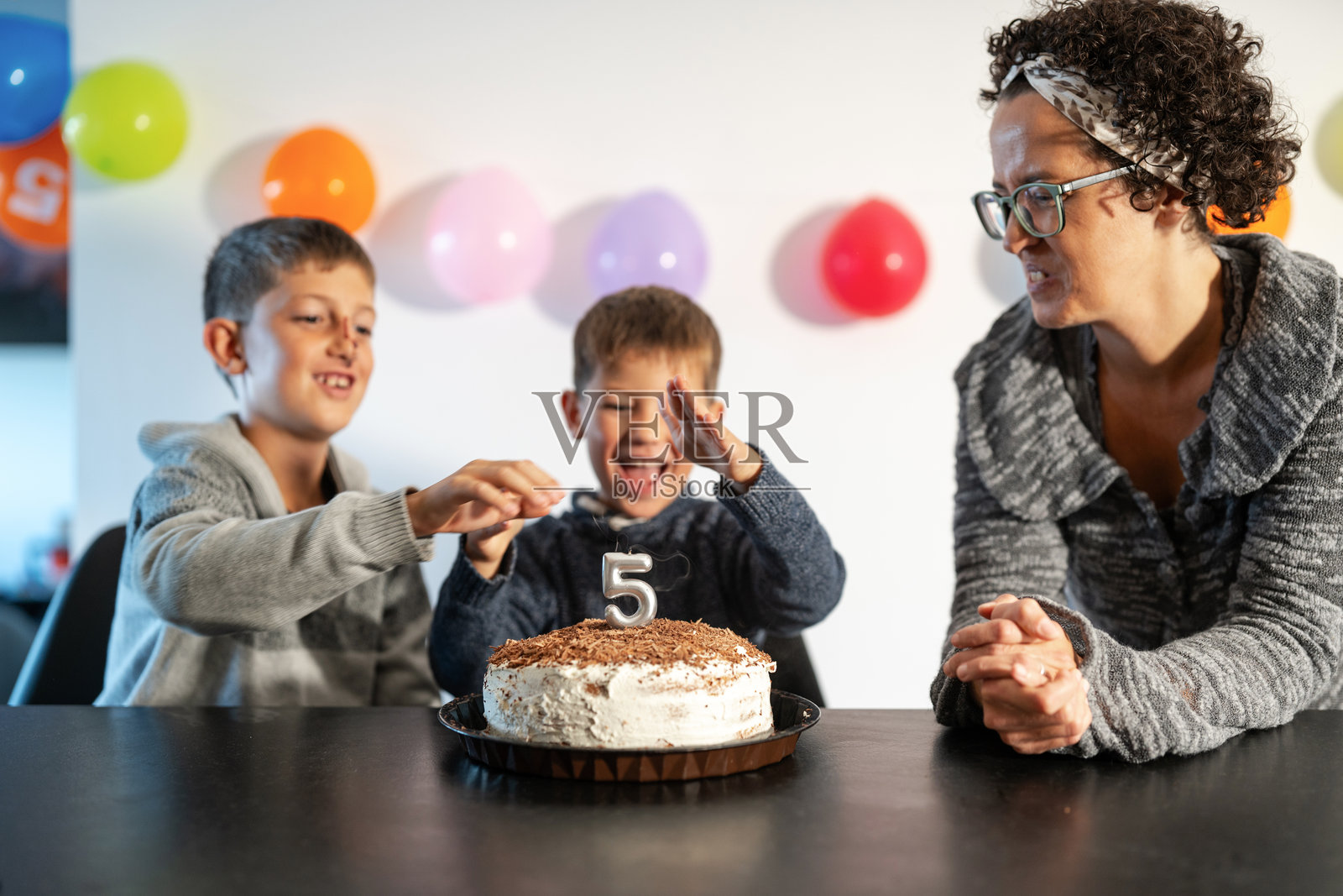 孩子们与家人一起庆祝五岁生日，享用蛋糕照片摄影图片