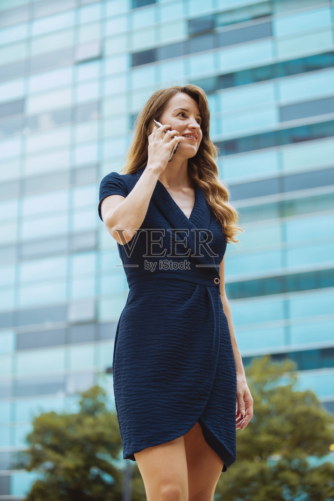 优雅的女商人在城市户外与智能手机交谈照片摄影图片