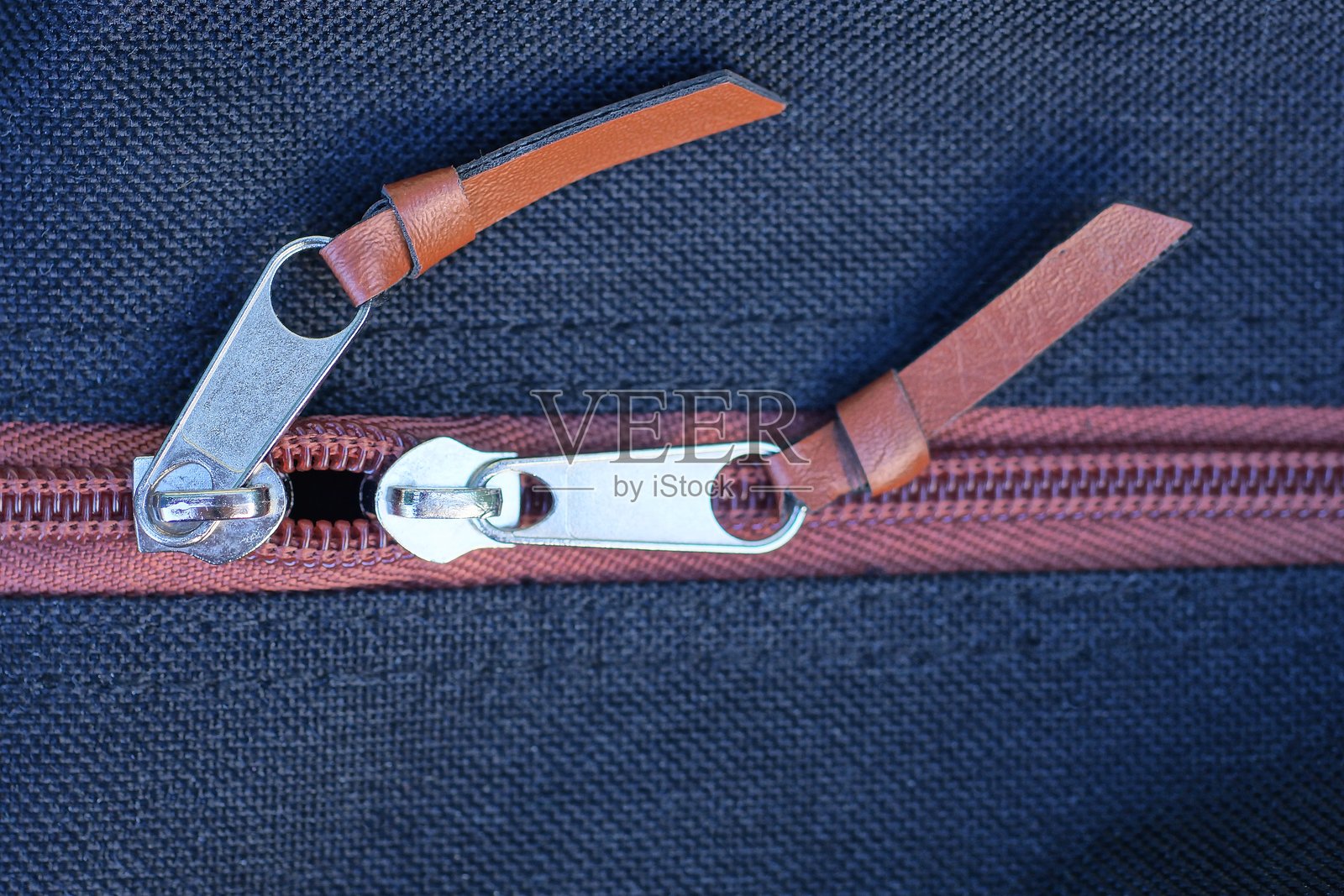 黑棕色面料包上的灰色金属拉链照片摄影图片