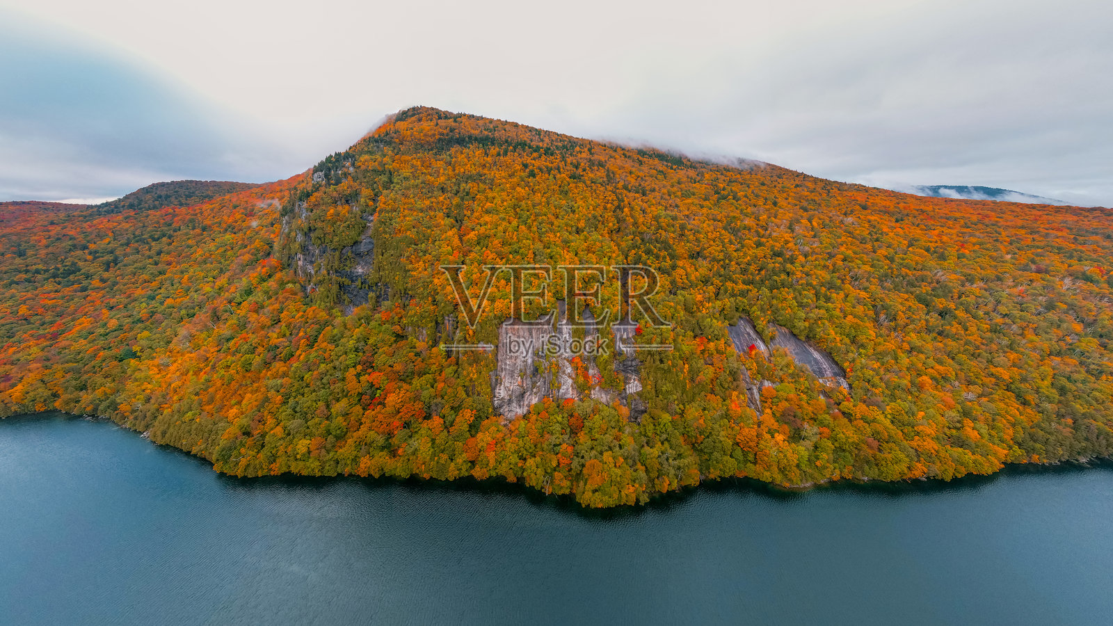史诗般的航拍山脉被秋季树叶覆盖。佛蒙特州威洛比湖的秋季景色，清晨五彩斑斓的树木与云朵相映成趣。照片摄影图片