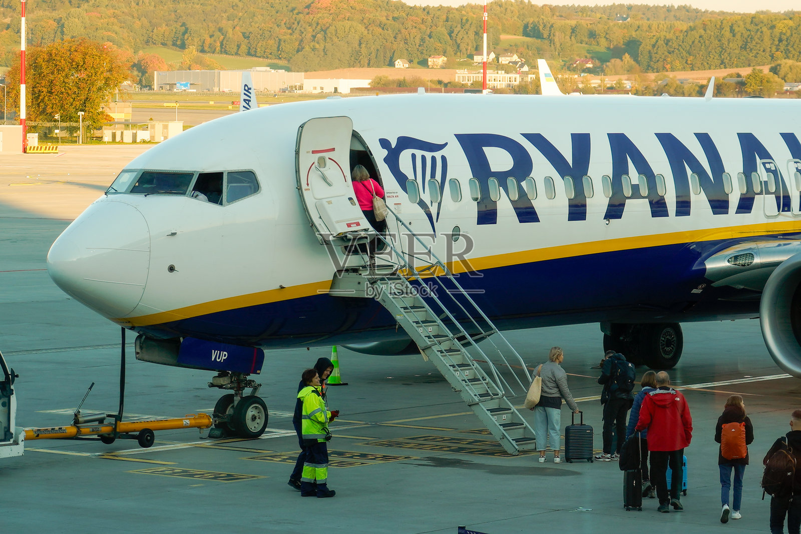 克拉科夫机场。航班起飞前的飞机处理（登机）。机场员工为飞机提供服务。行李装载（卸载）。乘客登机（到达）。照片摄影图片