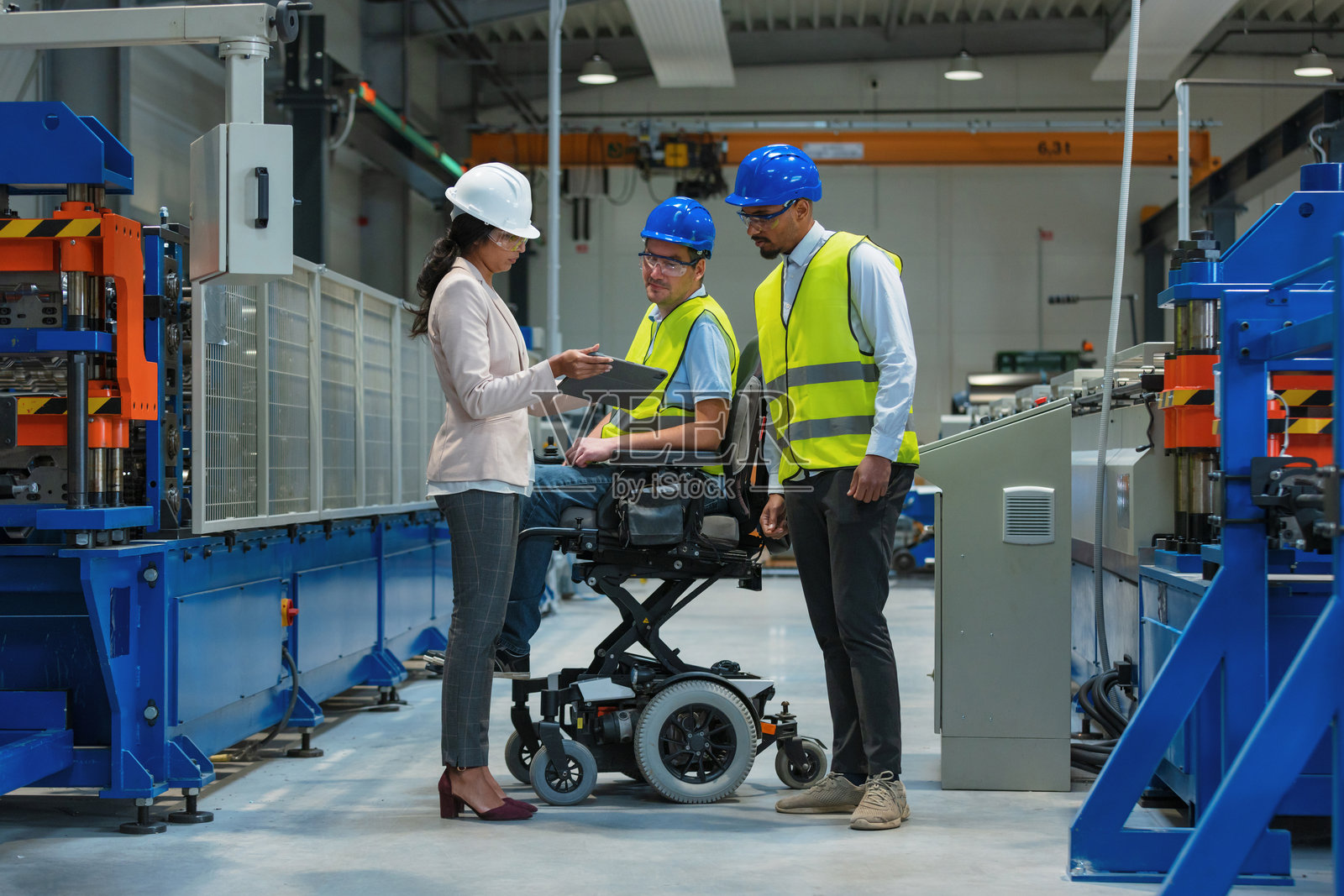 女经理与两名工人在生产线讨论生产情况照片摄影图片
