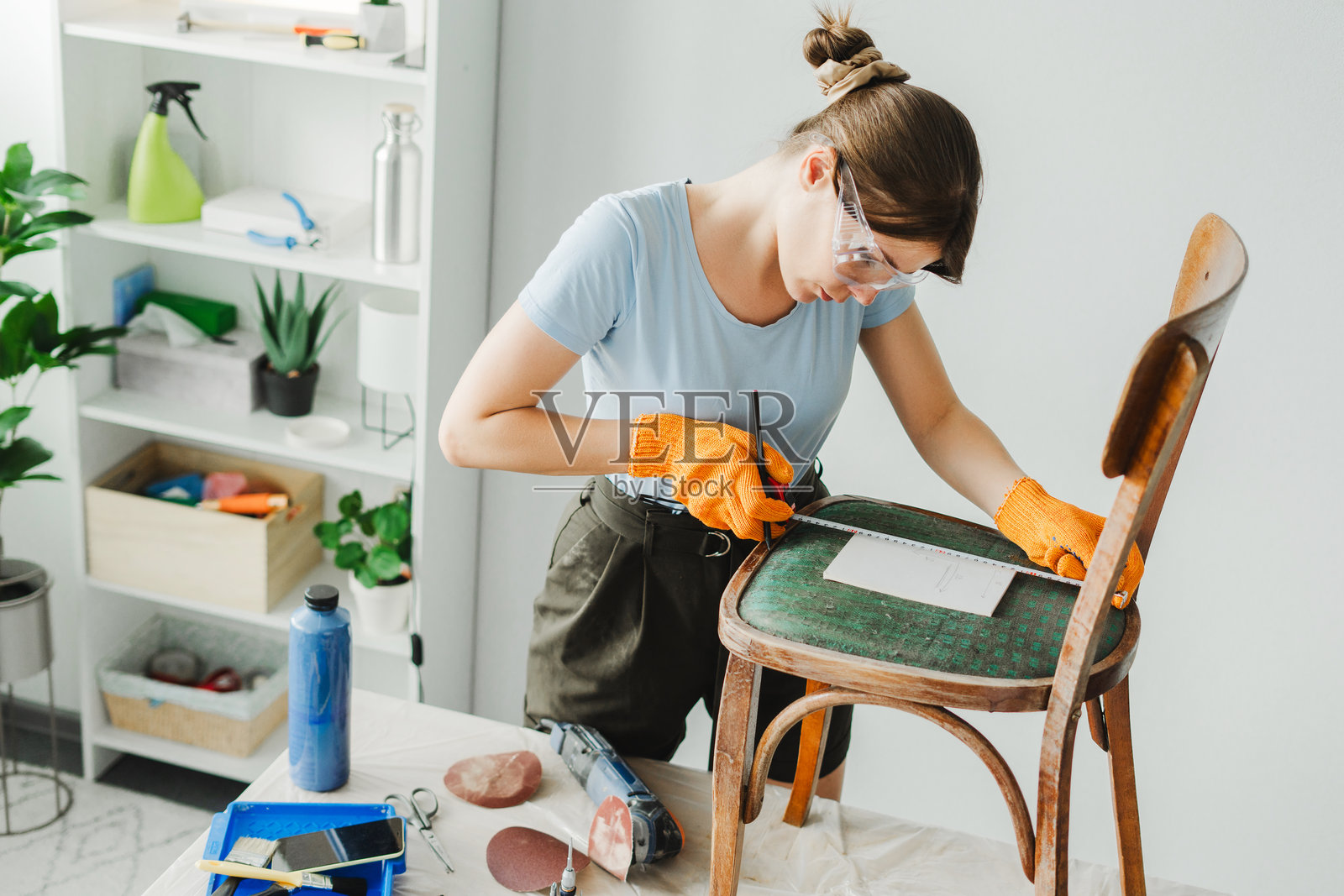 女性在工作坊中使用卷尺修复旧家具照片摄影图片