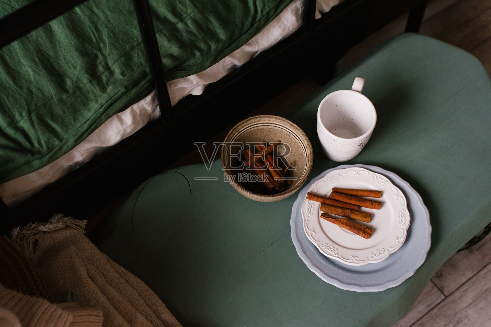 桌子上的盘子里放着茶杯和肉桂棒照片摄影图片