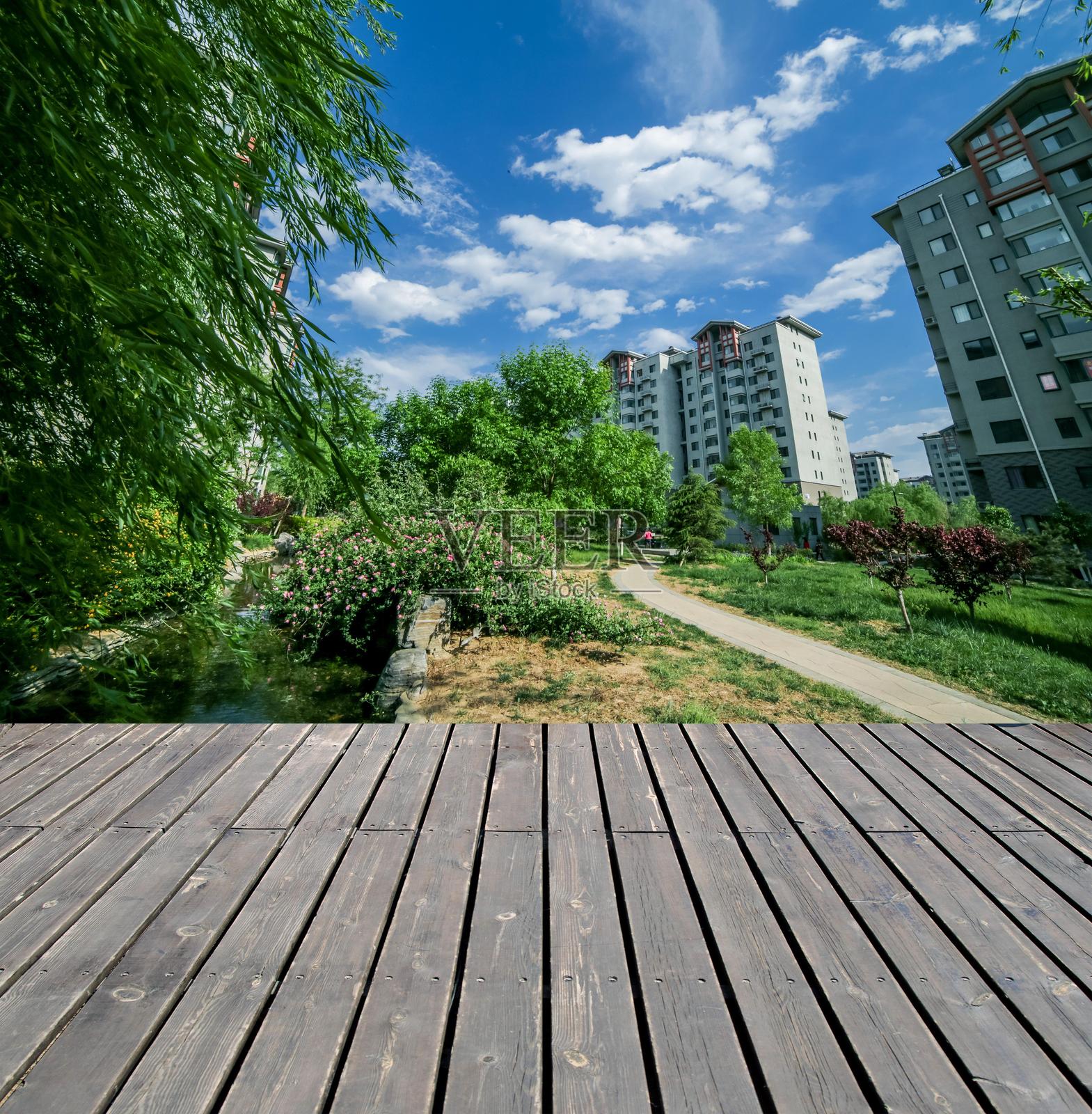 郁郁葱葱的公园里有一条木栈道，蓝天白云映衬其间。照片摄影图片