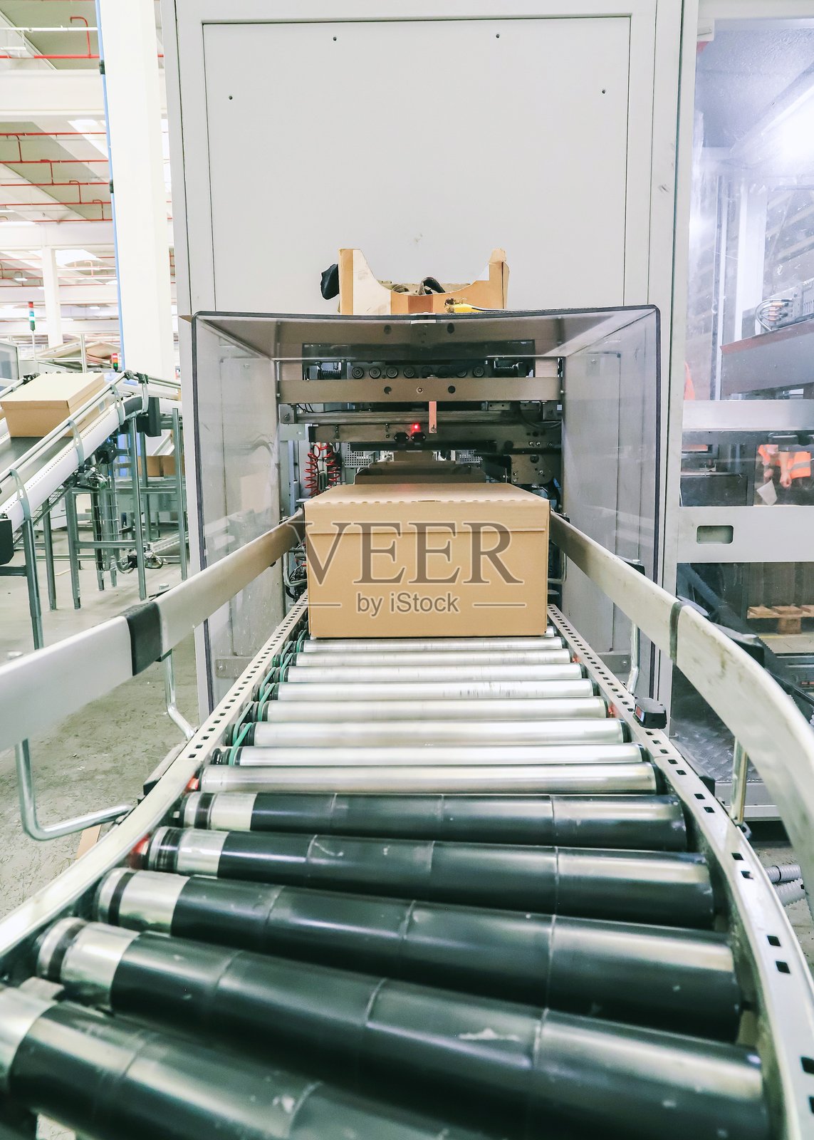 物流仓库中的包装线。现代生产线上的输送带。照片摄影图片
