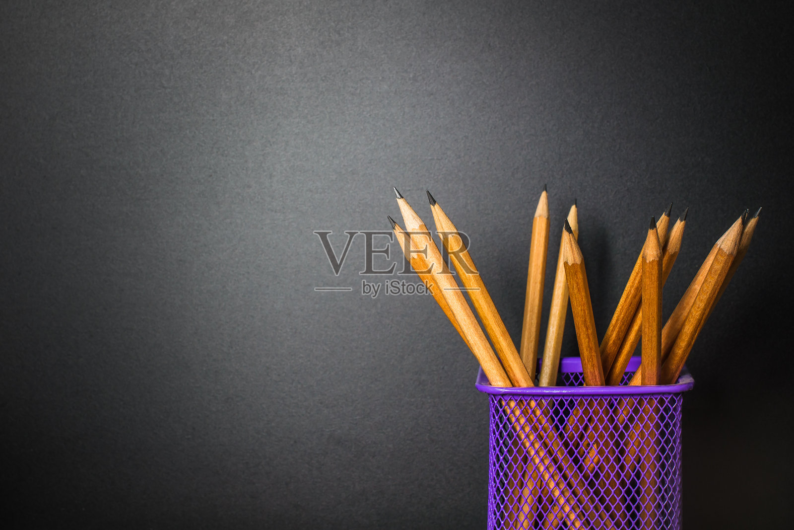 黑色背景下桌面收纳器中的铅笔特写照片摄影图片