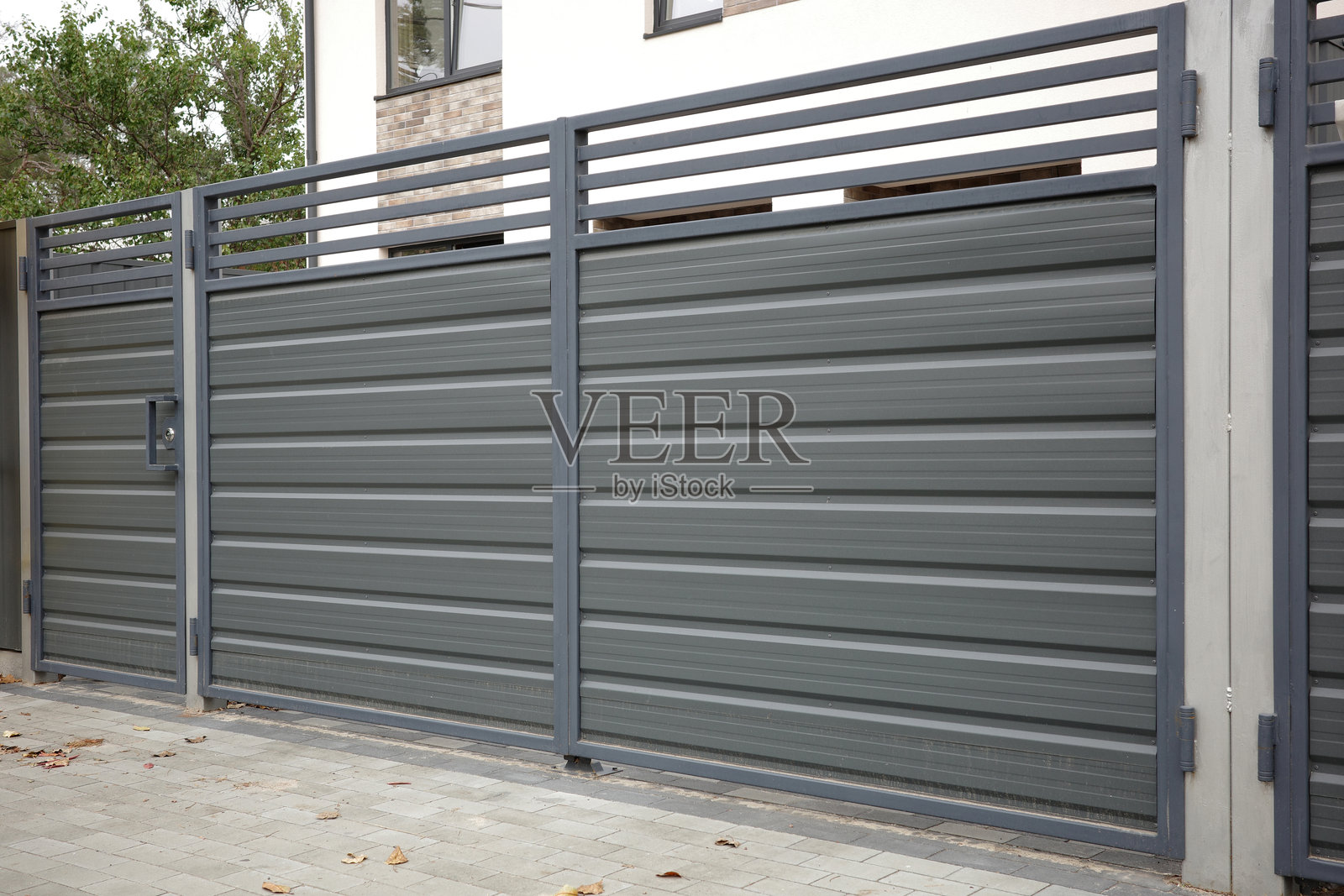 现代金属围栏用于围绕院子和车库区域。照片摄影图片