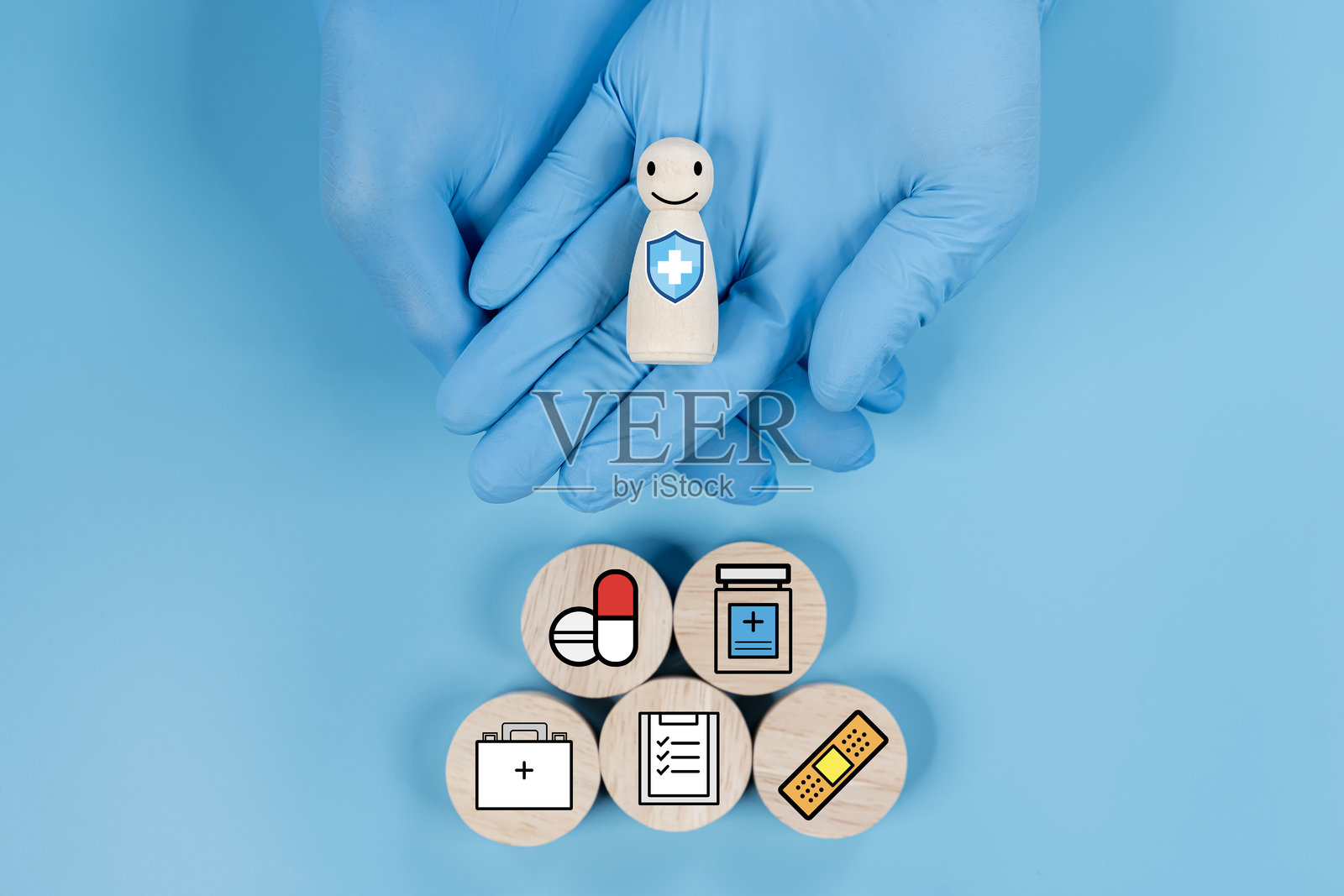医生手持带有微笑脸的木块，上面有与医疗相关的图标，如十字。照片摄影图片