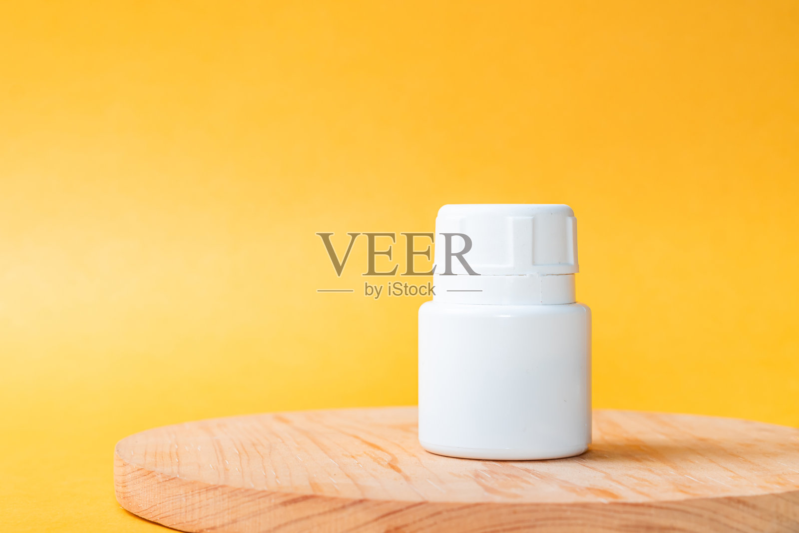 木质表面上的白色塑料瓶照片摄影图片