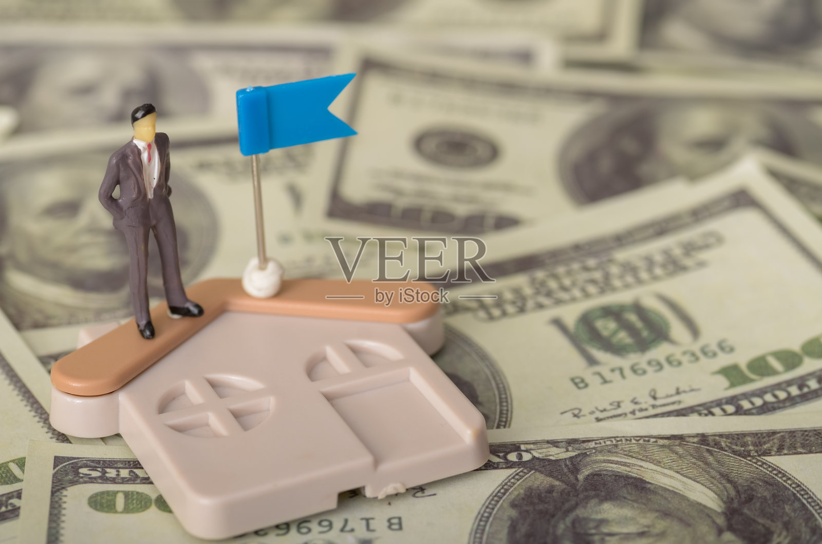 这位商人自豪地站在豪华物业前，手持国旗，展示了他在房地产市场的成功。照片摄影图片