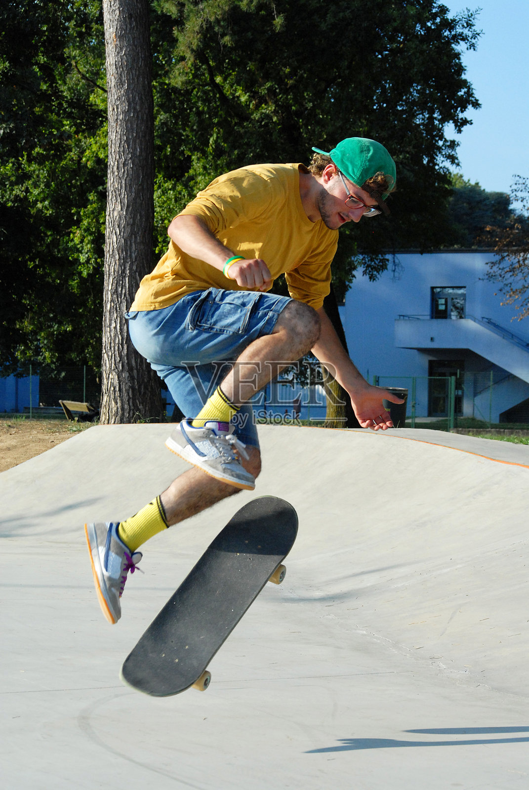 滑板男孩在城市公园跳跃和表演特技。照片摄影图片
