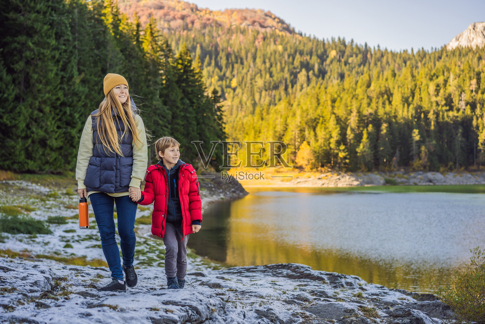母亲和儿子在黑湖（Crno Jezero）全景晨景的背景下旅游。宁静的夏季场景，位于黑山的杜尔米托国家公园（Durmitor Nacionalni Park），扎布贾克（Zabljak）。自然之美的概念背景。探索黑山的旅行概念。照片摄影图片
