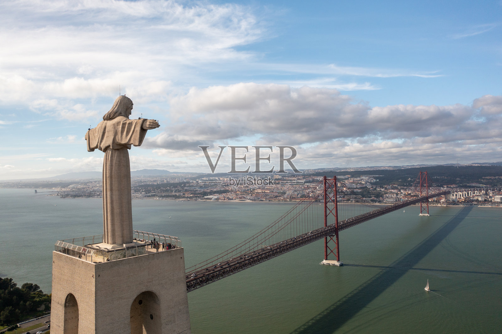 里斯本晴朗的日子里，基督王像俯瞰着25号四月大桥和特茹河的景色照片摄影图片