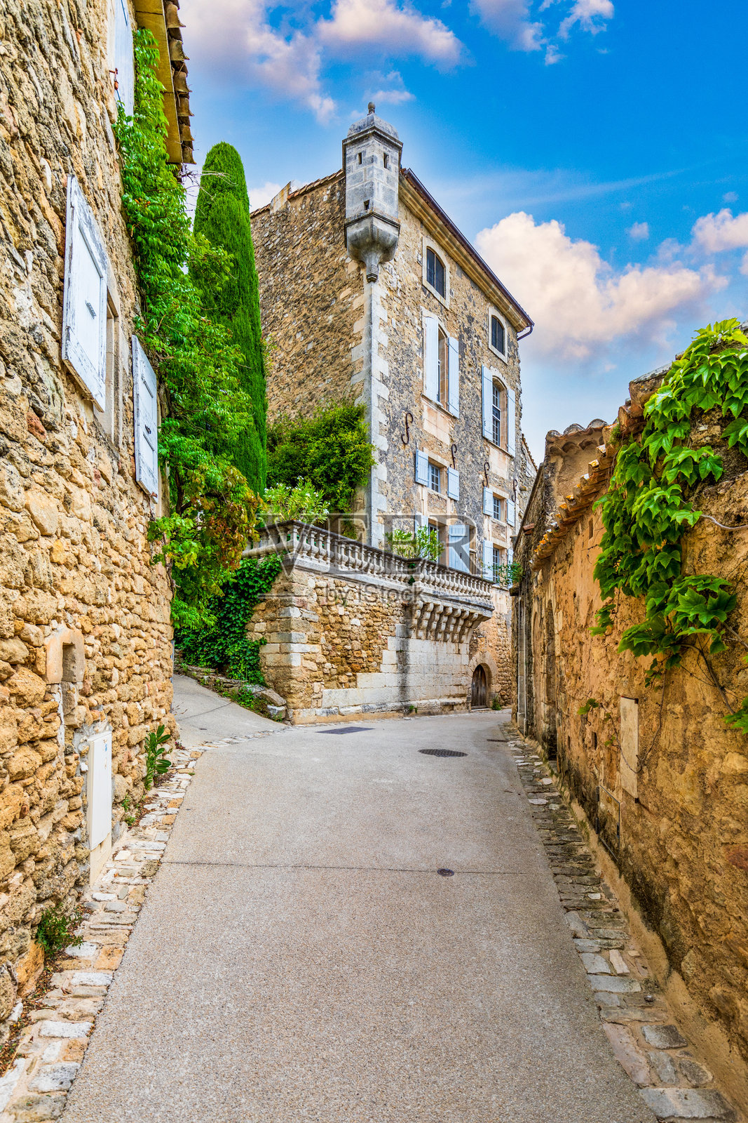 迷人的街道位于古雅的梅内尔布村，色彩斑斓的建筑和生机勃勃的花朵。梅内尔布村（法国最美丽的村庄）位于法国吕贝隆山脉，沃克吕兹省。照片摄影图片