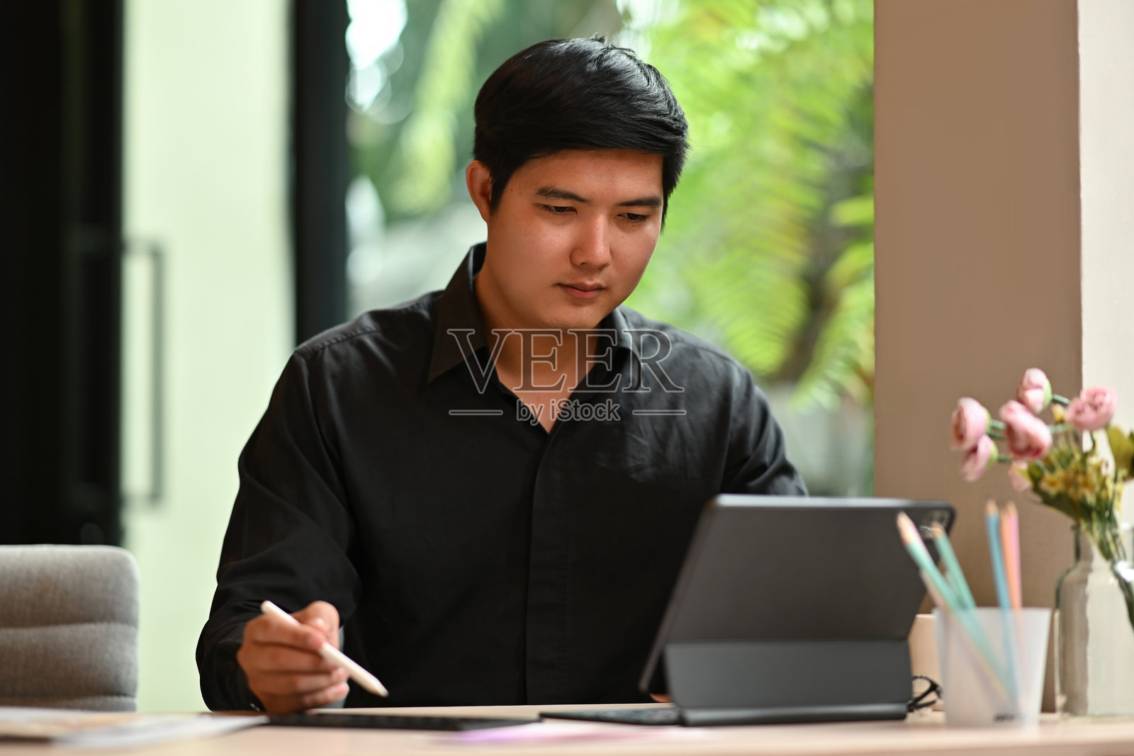 建筑师和室内设计师在选择和指点材料样本，同时使用平板电脑，设计师正在进行室内建筑和家具设计项目。照片摄影图片