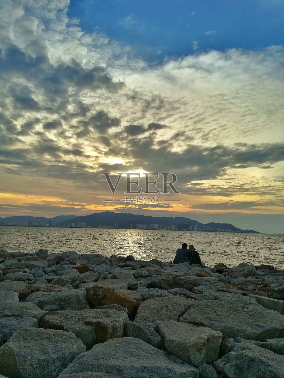 海边恩爱的一对情侣。照片摄影图片