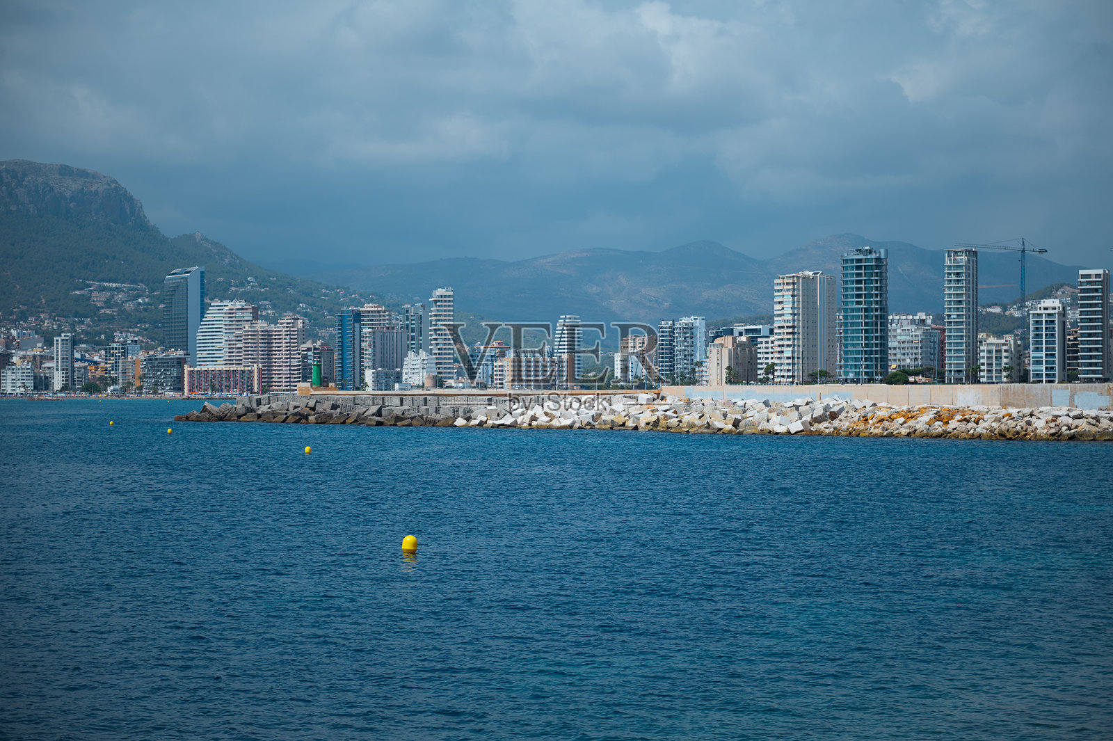 海滨城市天际线与背景中的山脉照片摄影图片