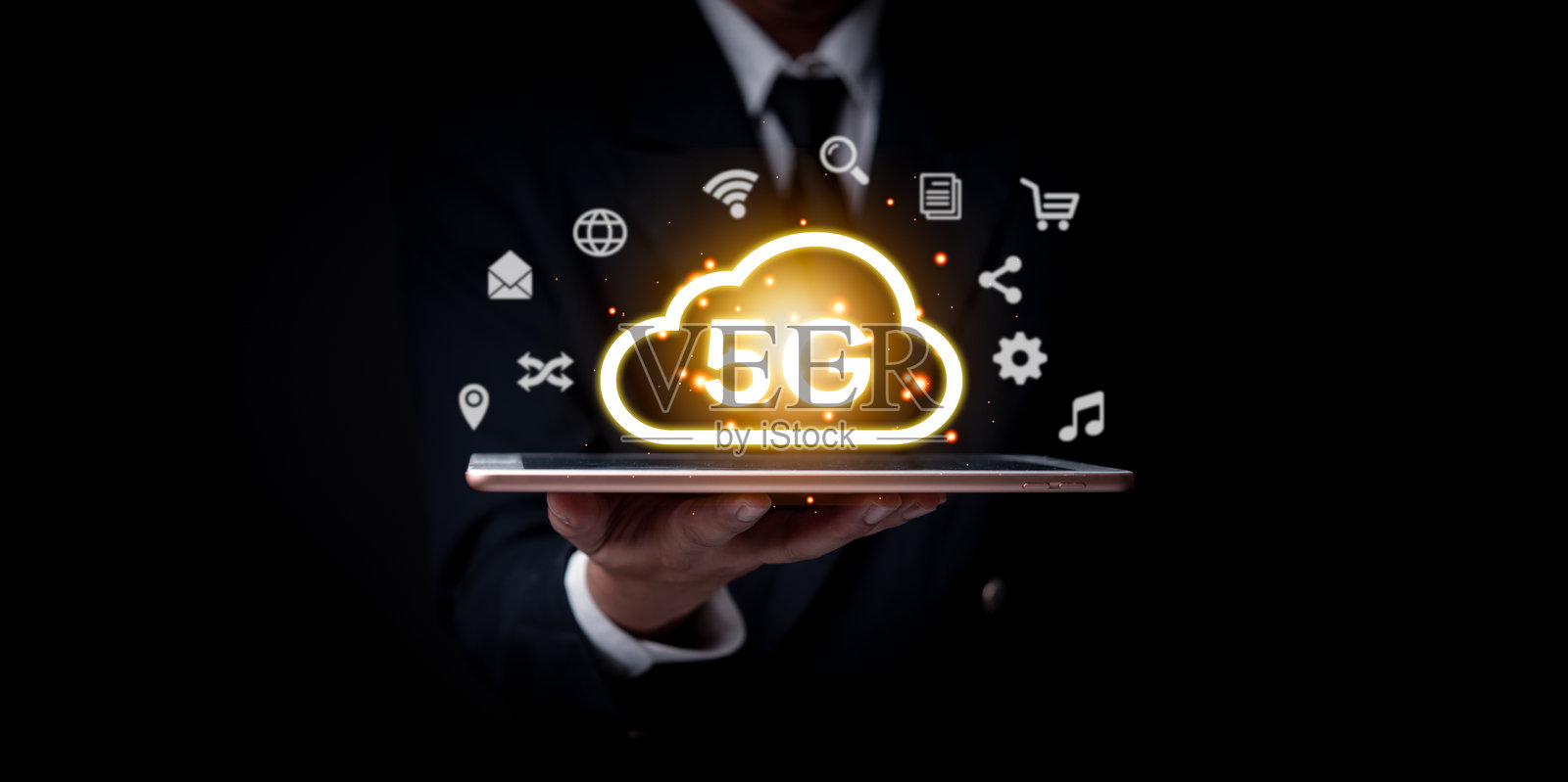 一位商人手持一台平板电脑，上面显示着5G云图标，代表高速无线互联网技术。照片摄影图片