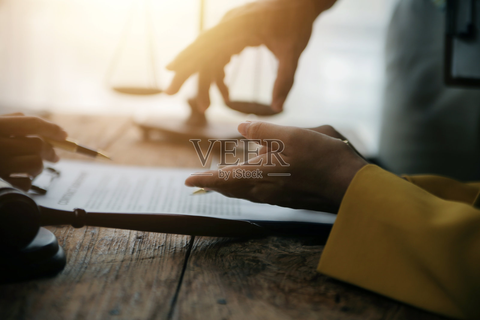 商务人士和律师在办公室讨论合同文件，桌上有一个铜制天平。法律、法律服务、咨询、正义和法律概念的图片，带有胶卷颗粒效果。照片摄影图片