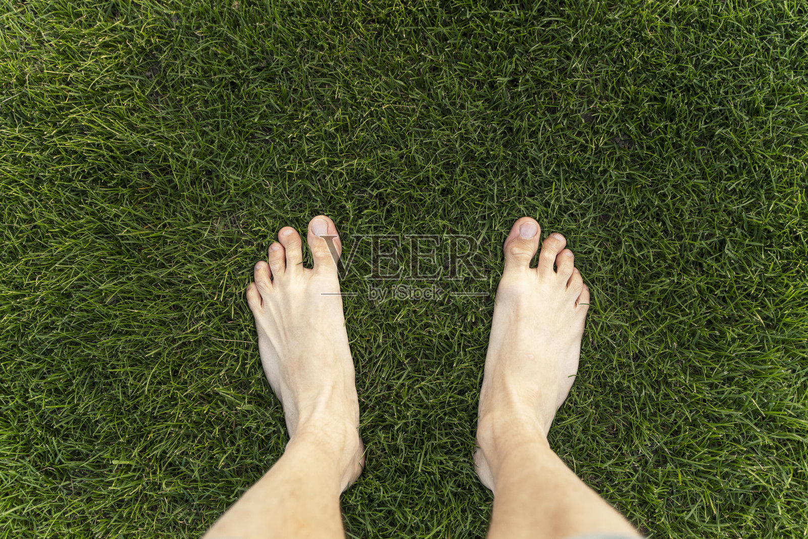 赤脚站在绿色草坪上的男人纹理背景照片摄影图片