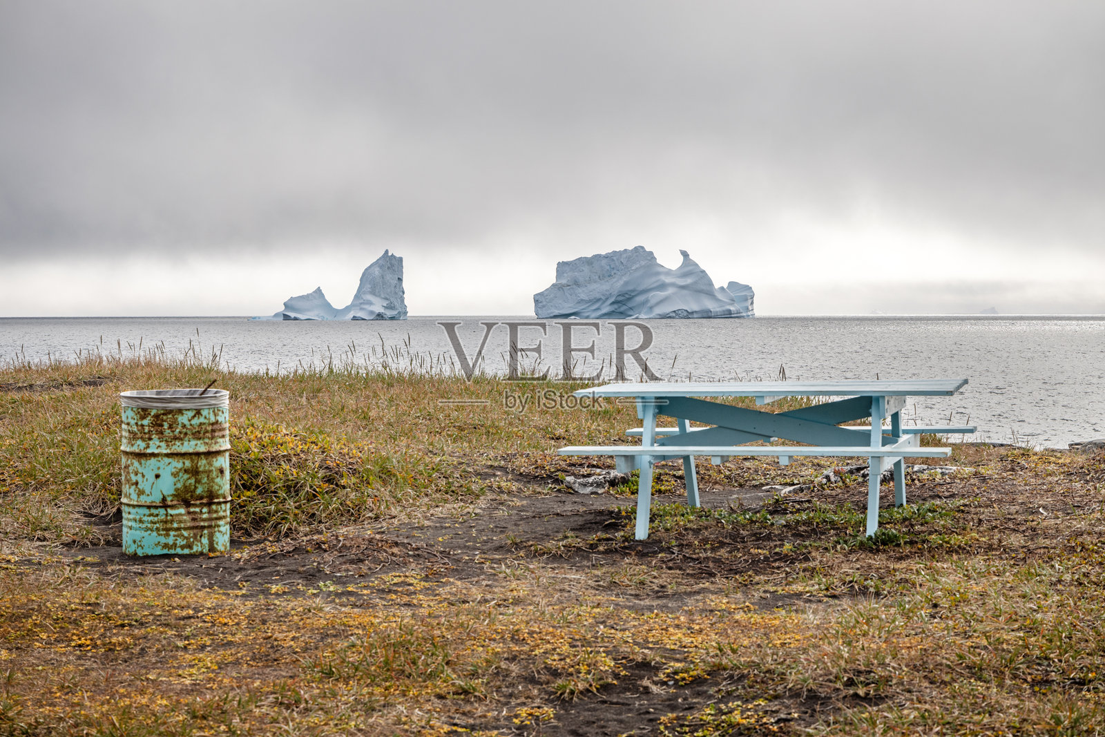 漂浮的冰山前有一张长椅和一个垃圾桶照片摄影图片